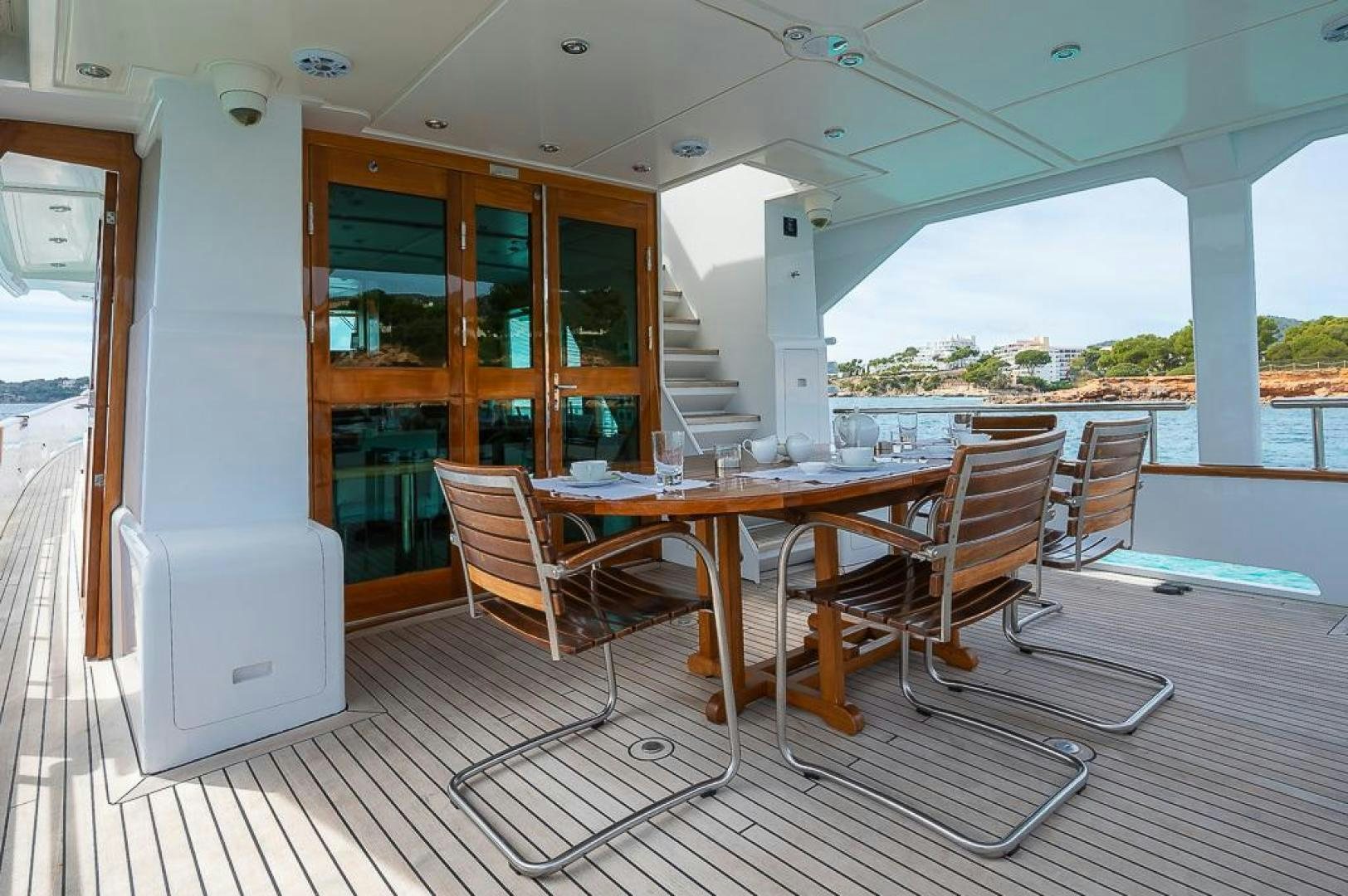 a table and chairs on a deck aboard CAPELLA Yacht for Sale