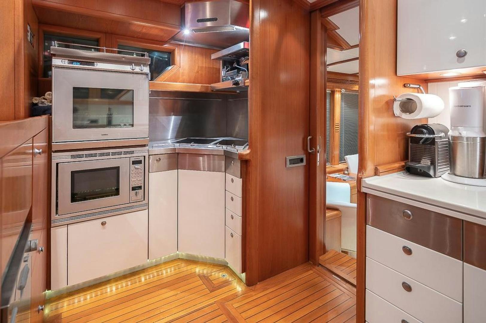 a kitchen with wooden cabinets aboard CAPELLA Yacht for Sale