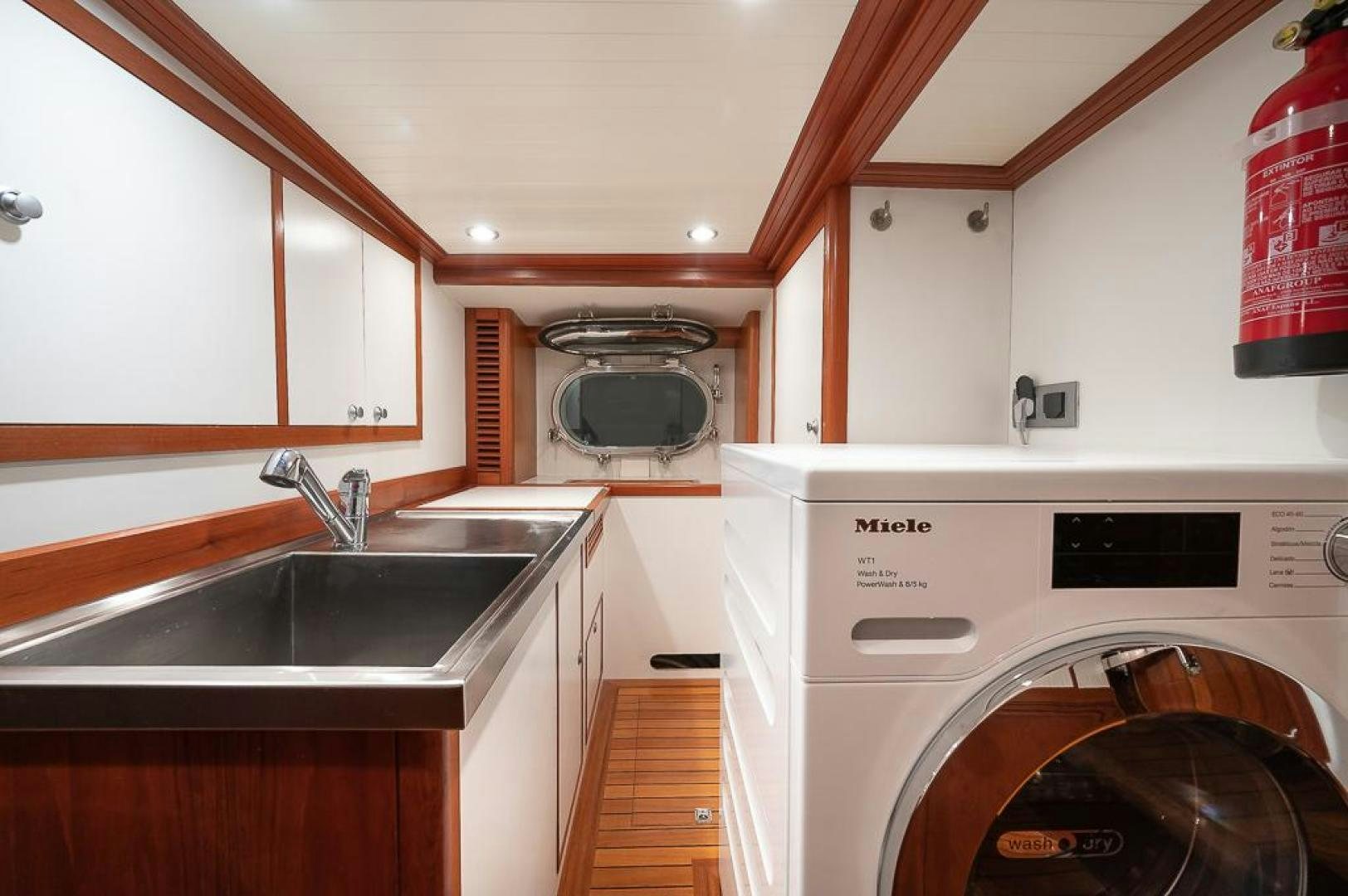 a kitchen with white cabinets aboard CAPELLA Yacht for Sale