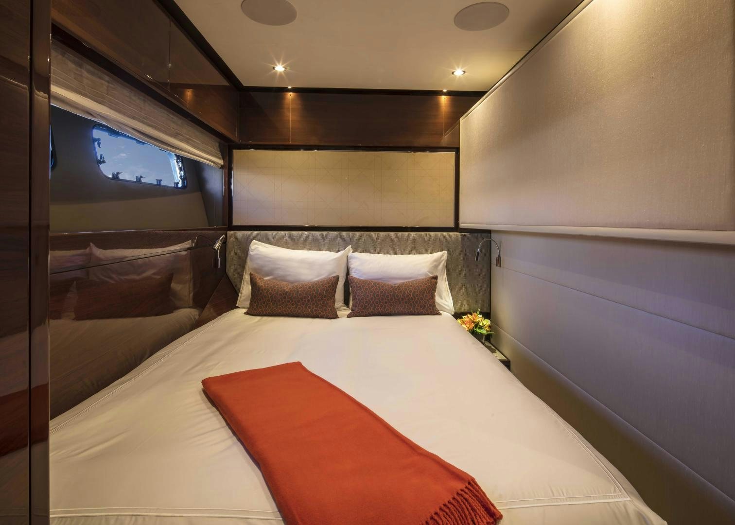 a bed with a white sheet and orange pillows aboard HOT PURSUIT Yacht for Sale