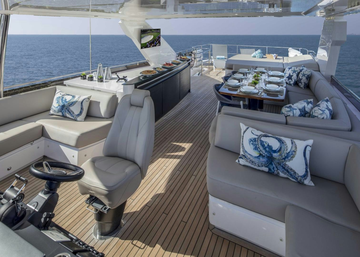 a room with a couch and a table and a large window aboard HOT PURSUIT Yacht for Sale