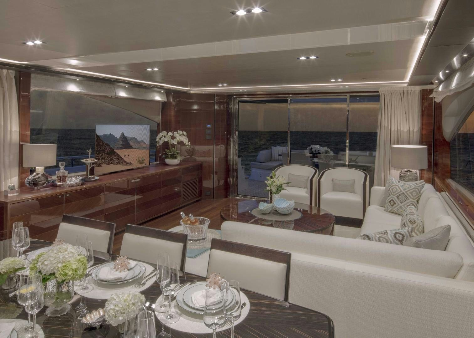 a room with a table chairs and flowers aboard HOT PURSUIT Yacht for Sale