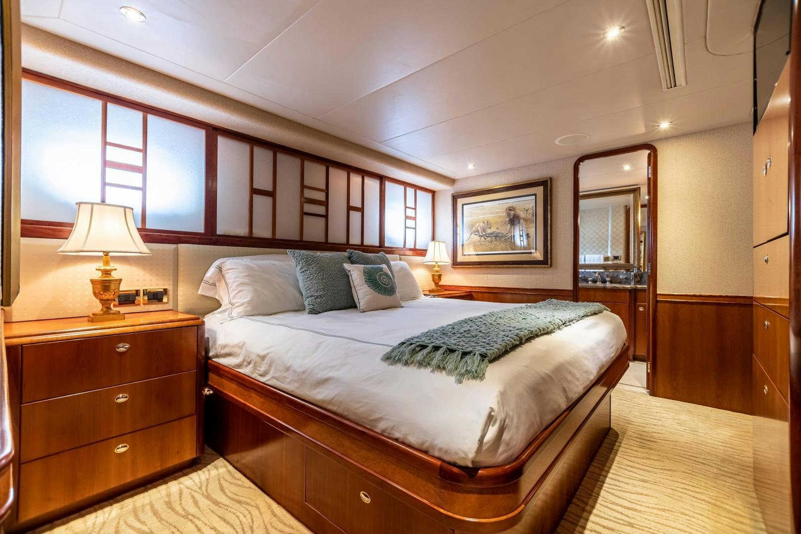 a bedroom with a bed and a dresser aboard SERENGETI Yacht for Sale