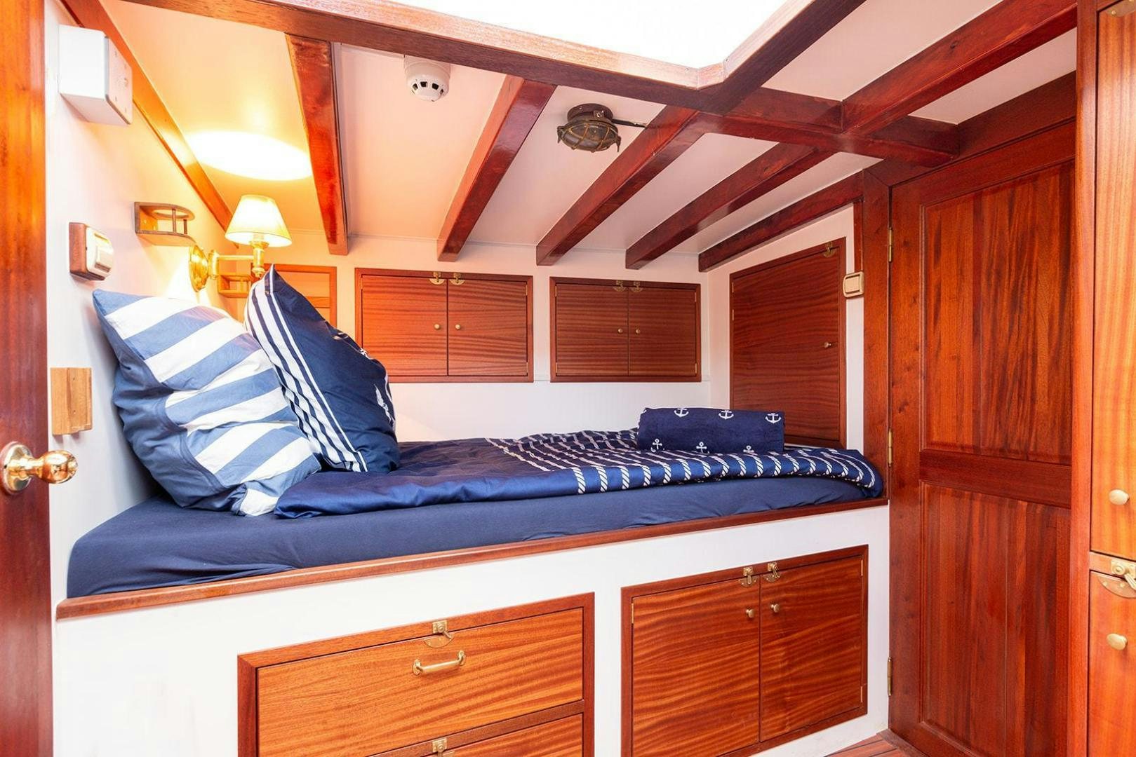 a bed with a blue comforter aboard SKYTHIA Yacht for Sale