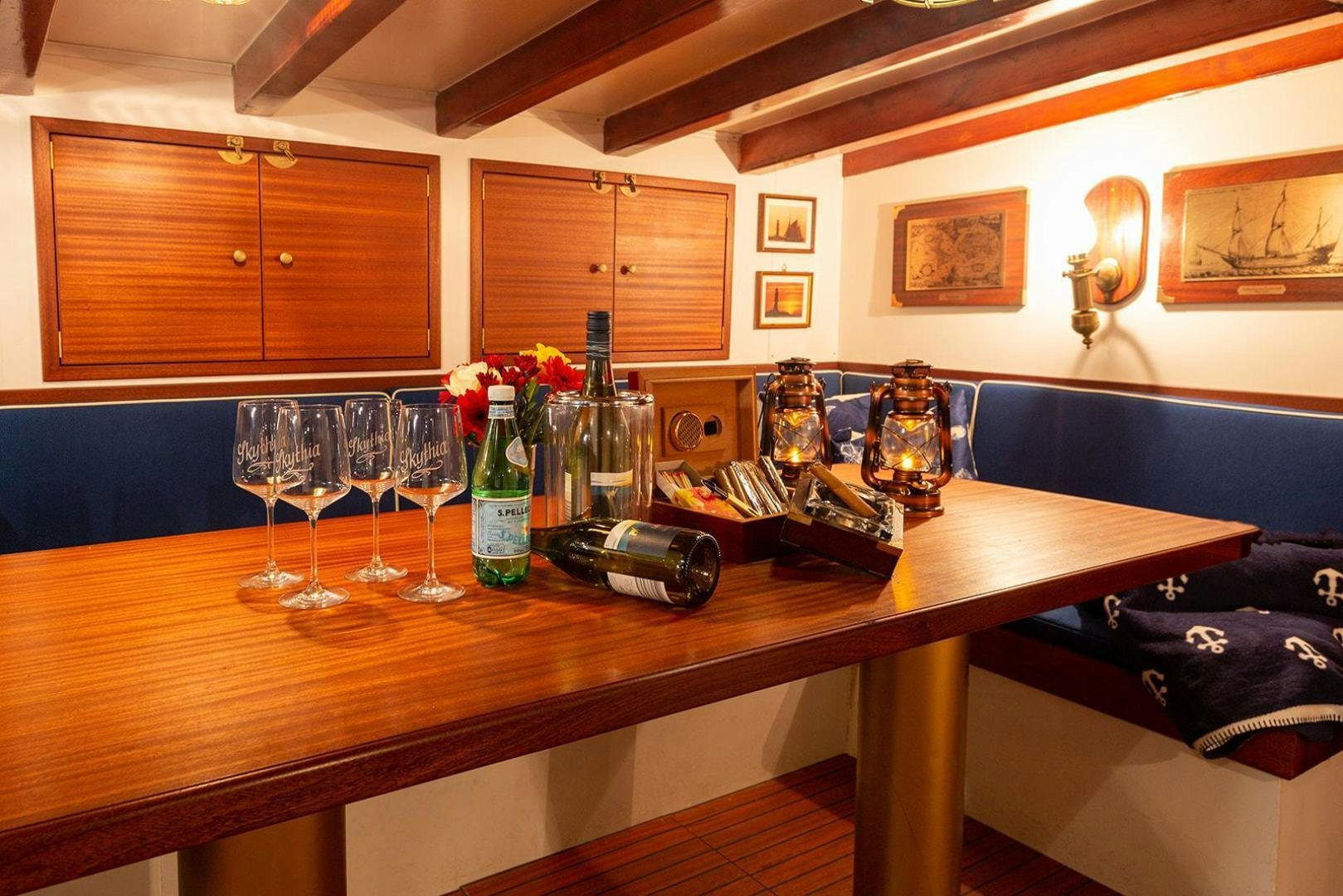 a table with wine glasses and bottles aboard SKYTHIA Yacht for Sale