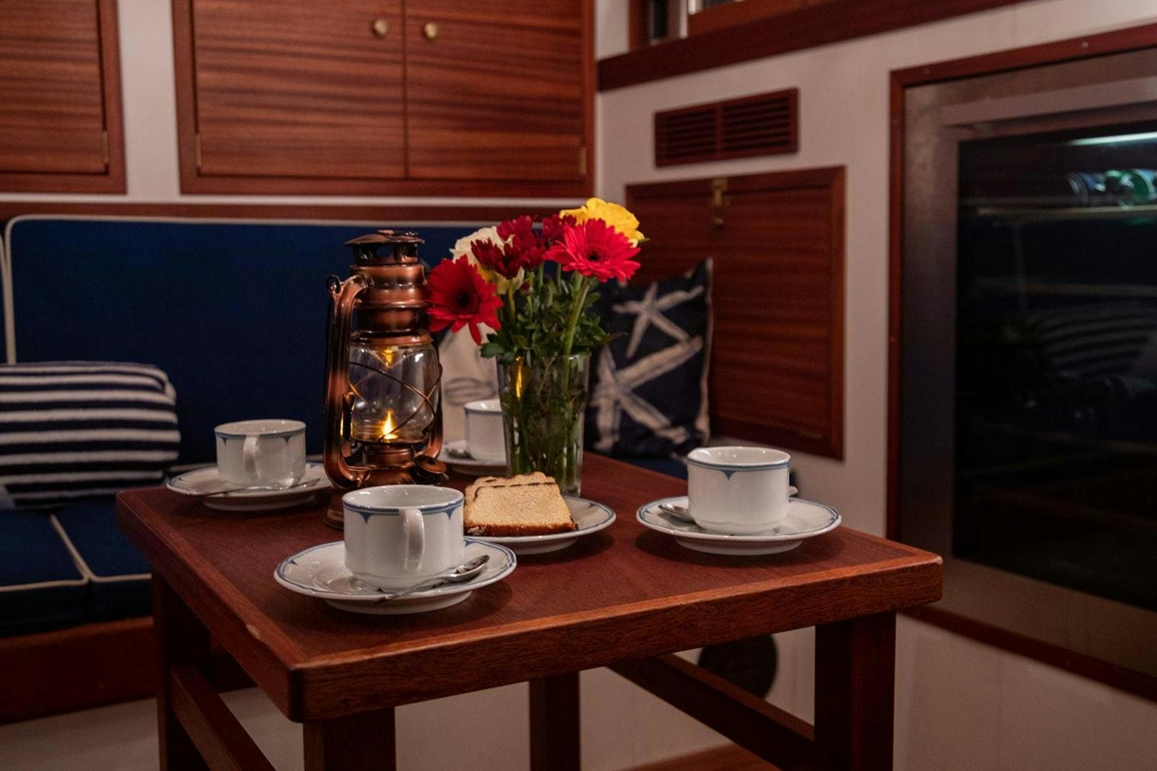 a table with a vase of flowers and teapots on it aboard SKYTHIA Yacht for Sale
