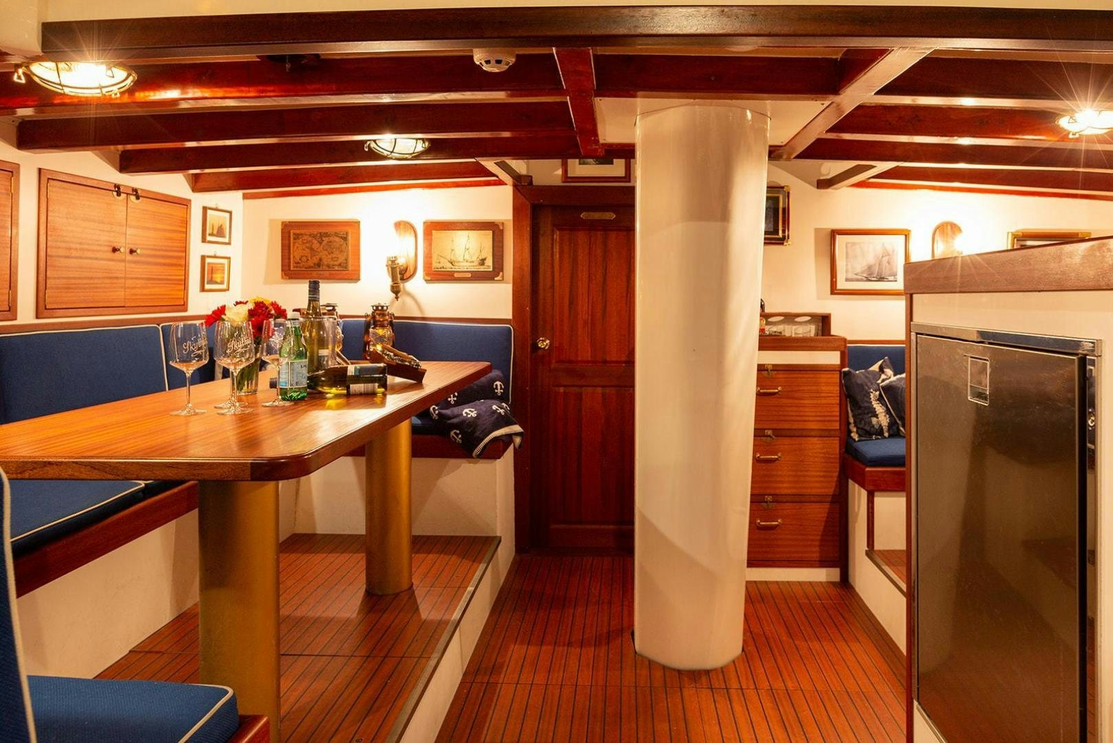 a kitchen with a table and refrigerator aboard SKYTHIA Yacht for Sale