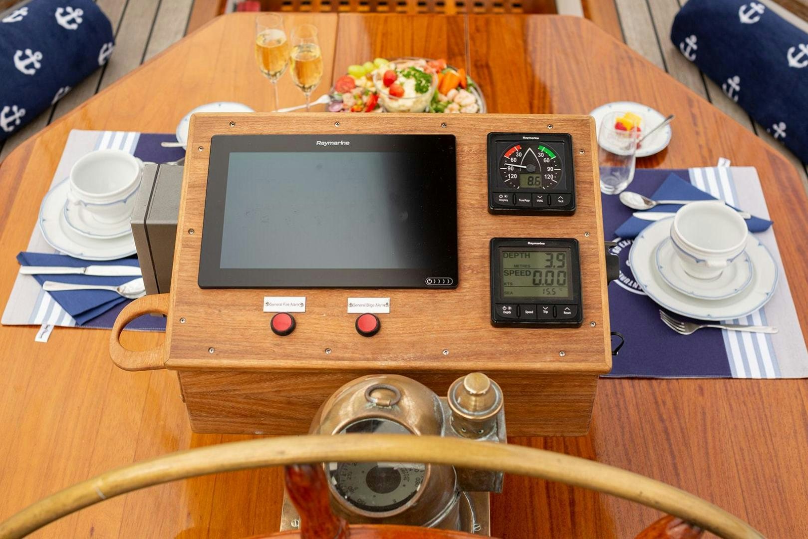 a table with a television and plates aboard SKYTHIA Yacht for Sale