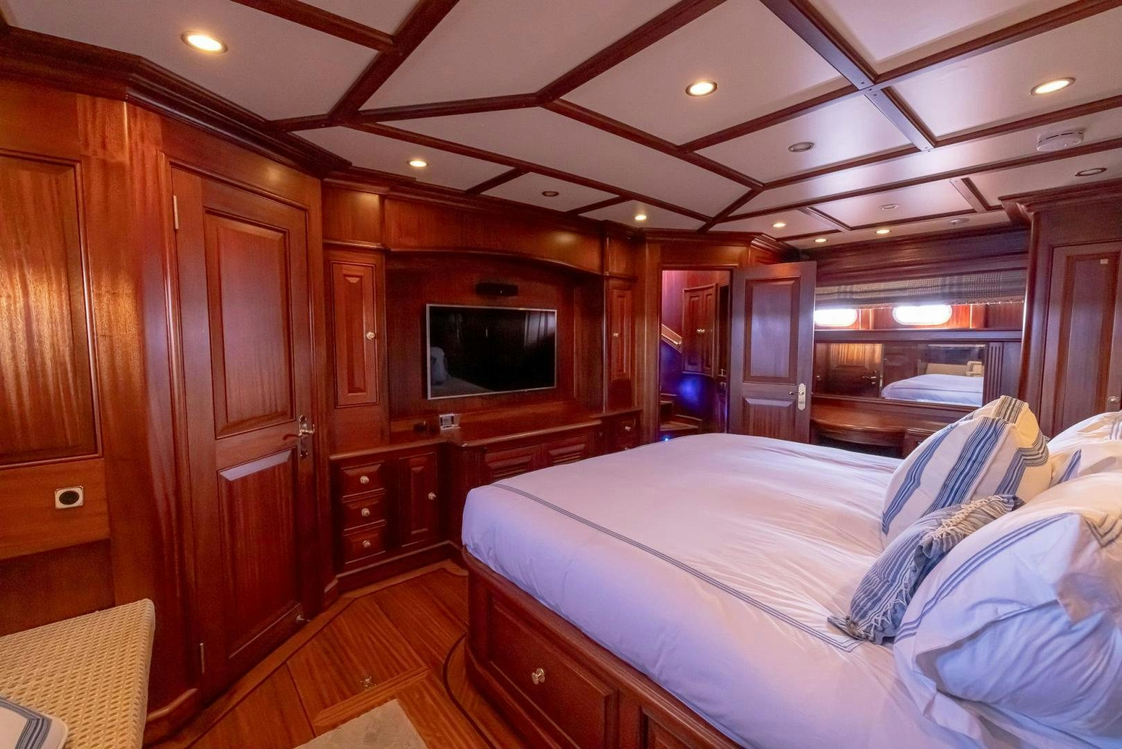 a bedroom with a bed and a television aboard ESSENCE OF CAYMAN Yacht for Sale