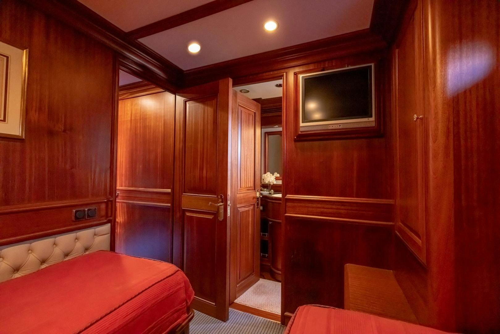 a room with a bed and a television aboard ESSENCE OF CAYMAN Yacht for Sale