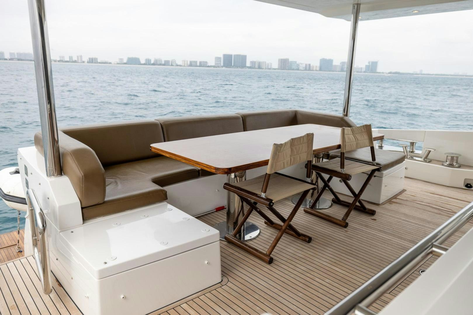 a room with a table and chairs on a deck overlooking a city aboard HAPPY HOURS Yacht for Sale