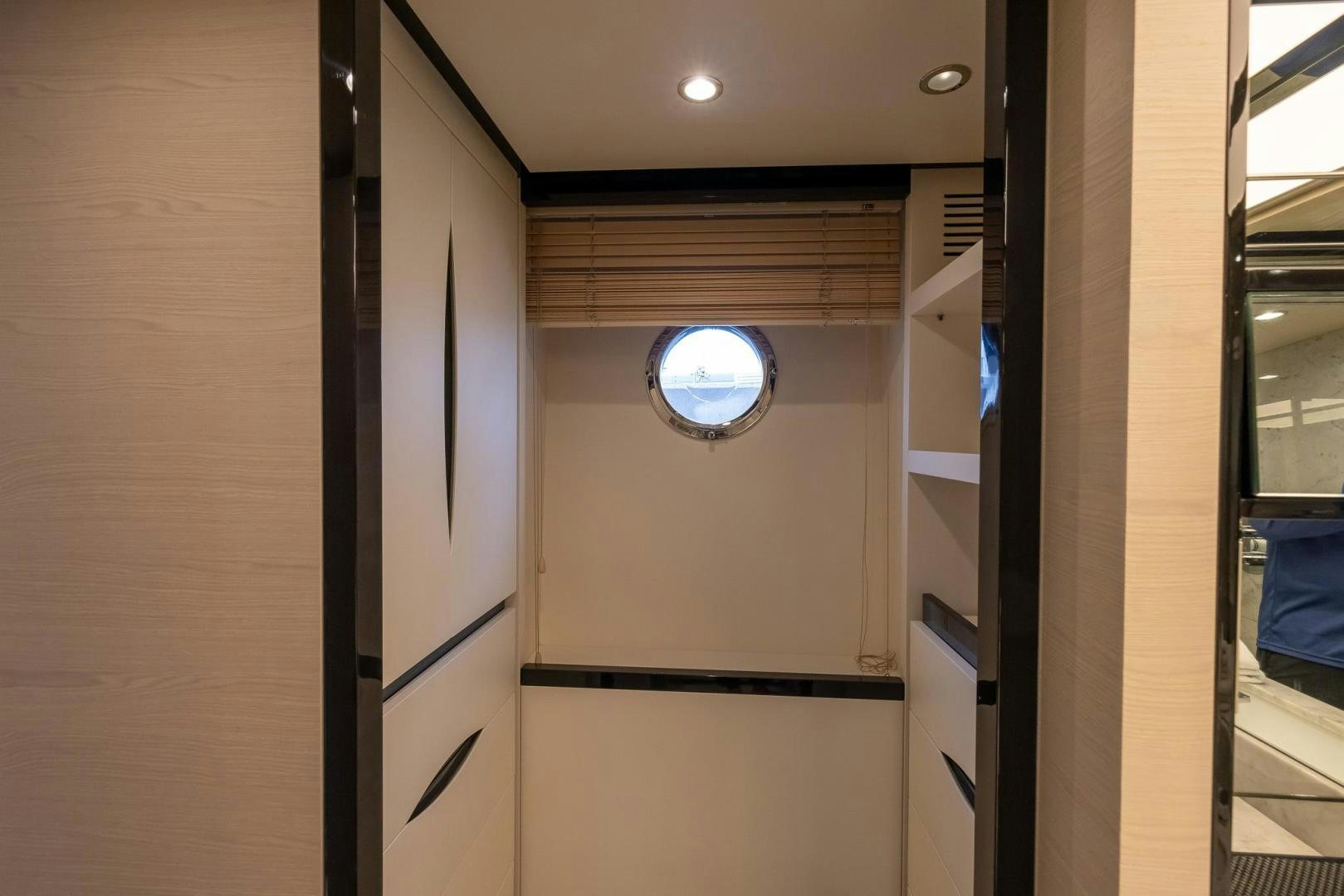 a hallway with a window and a door with a clock on it aboard HAPPY HOURS Yacht for Sale