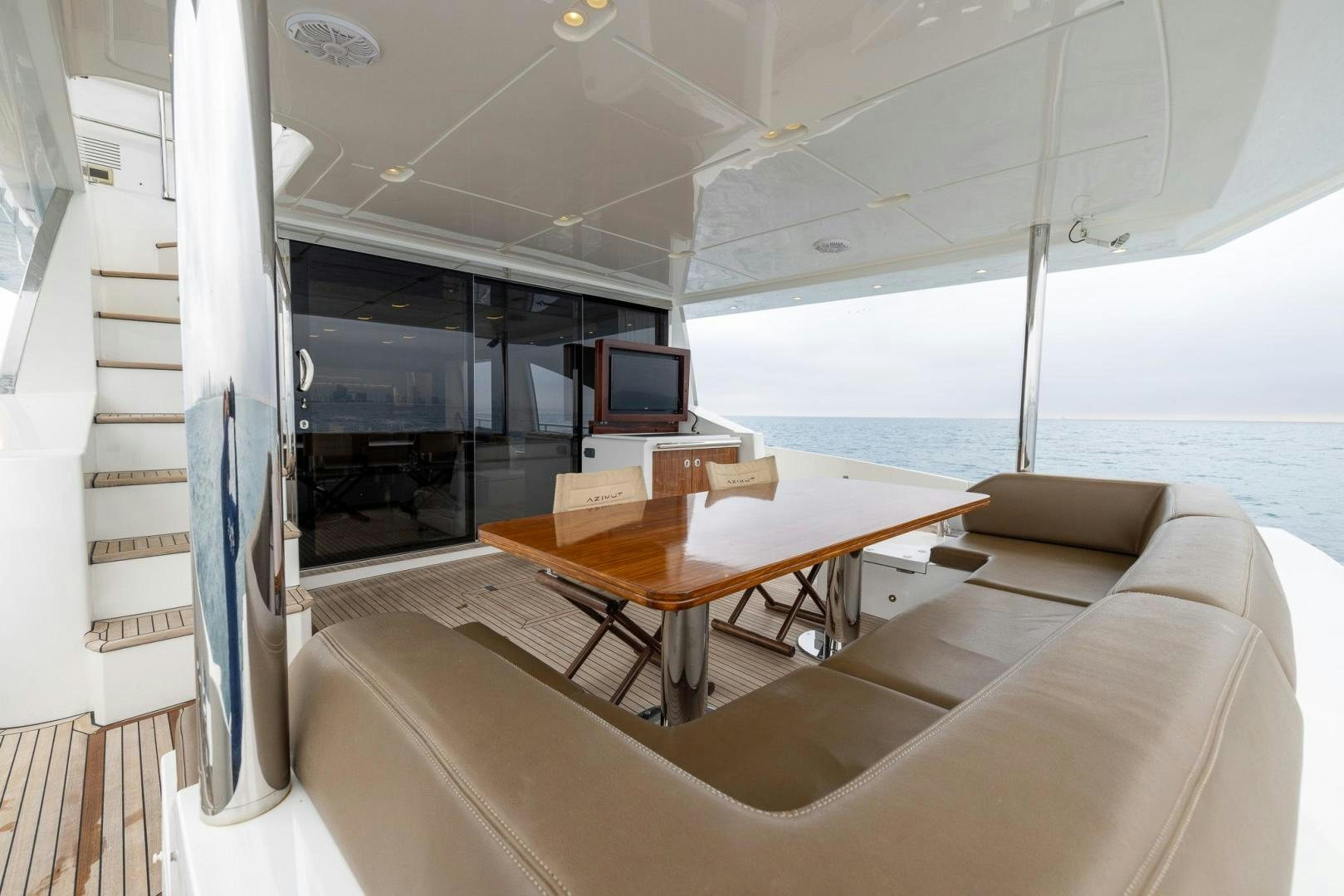 a room with a table and a tv on the wall aboard HAPPY HOURS Yacht for Sale