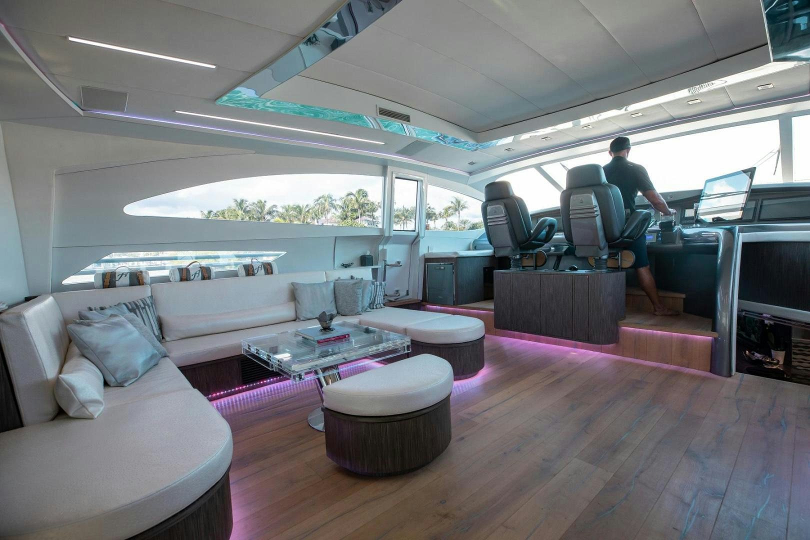 a person sitting in a chair in a room with a table and a couch aboard AMORA Yacht for Sale