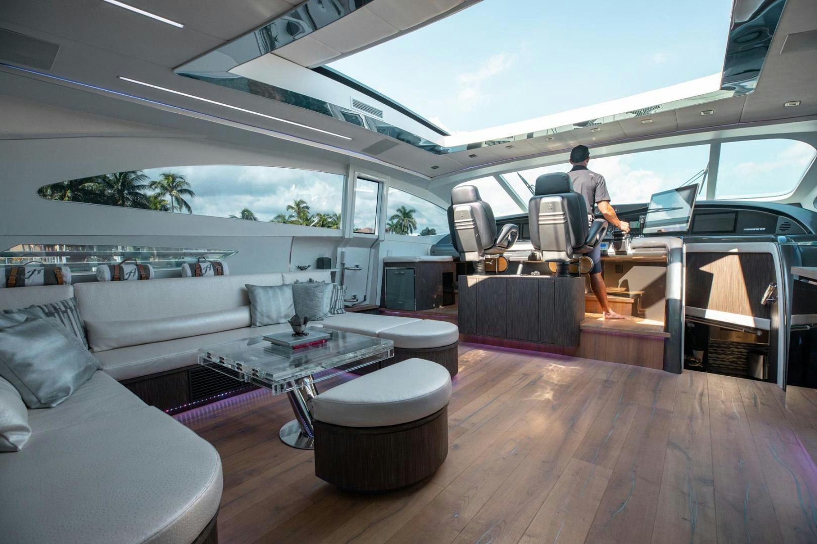 a person working on a laptop in a living room aboard AMORA Yacht for Sale