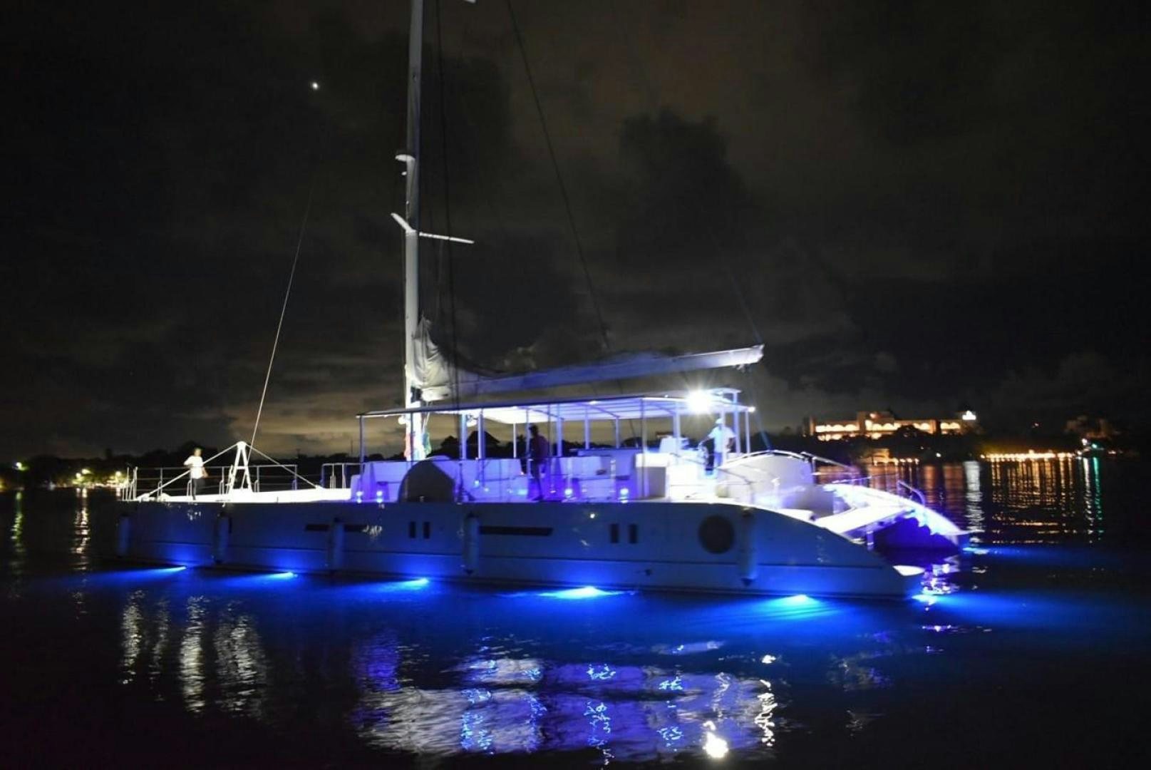 a boat with lights on at night aboard COMPASS Yacht for Sale