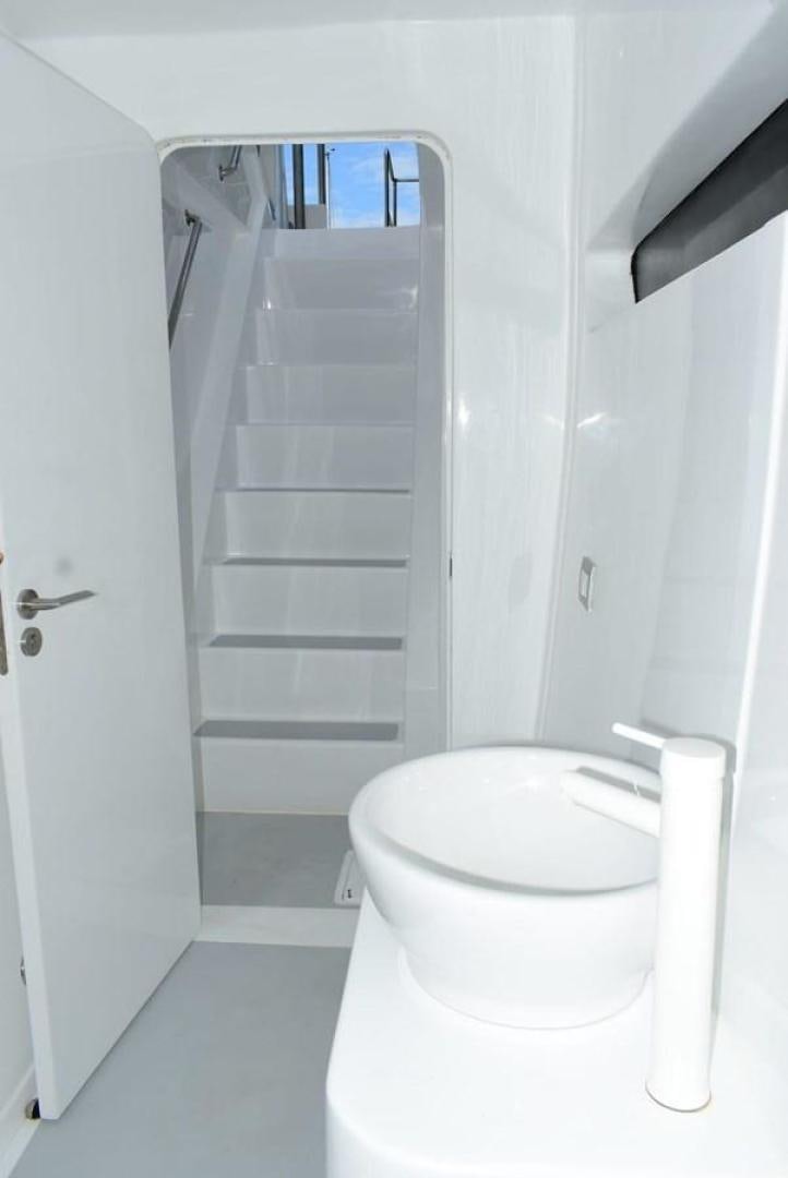 a white toilet with a shelf aboard COMPASS Yacht for Sale