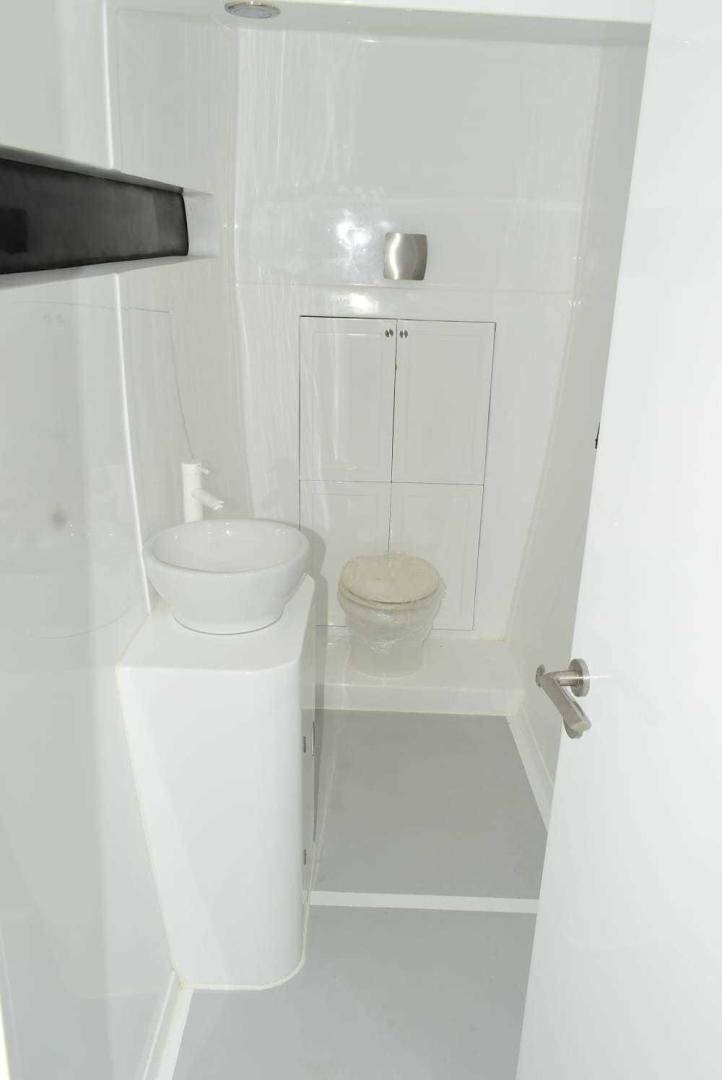 a white bathroom with a white cabinet aboard COMPASS Yacht for Sale