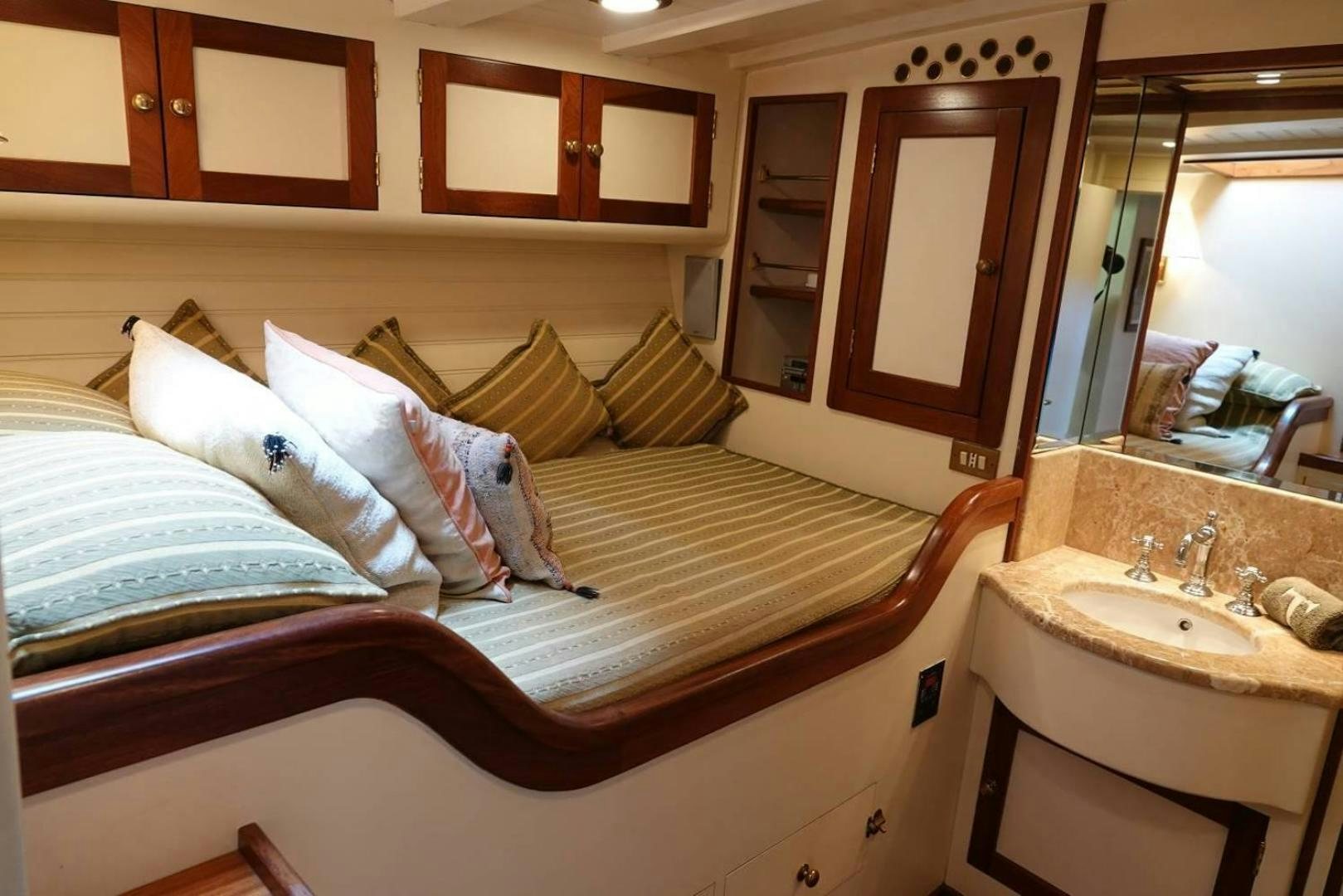 a bed with a wooden headboard aboard TAMORY Yacht for Sale