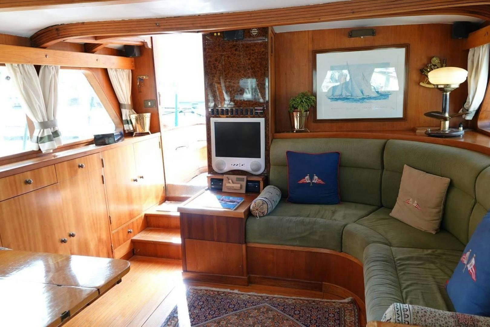 a living room with a green couch aboard TAMORY Yacht for Sale