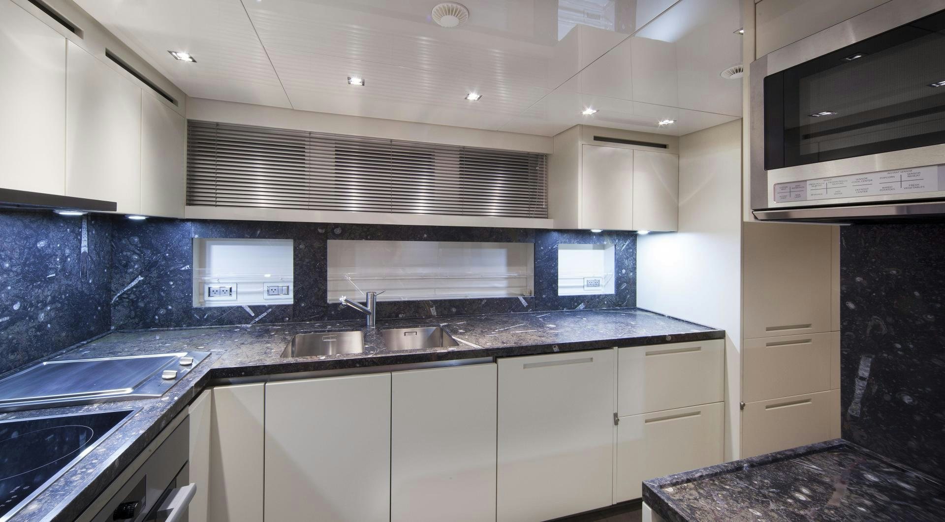 a kitchen with black counter tops aboard BODACIOUS Yacht for Sale