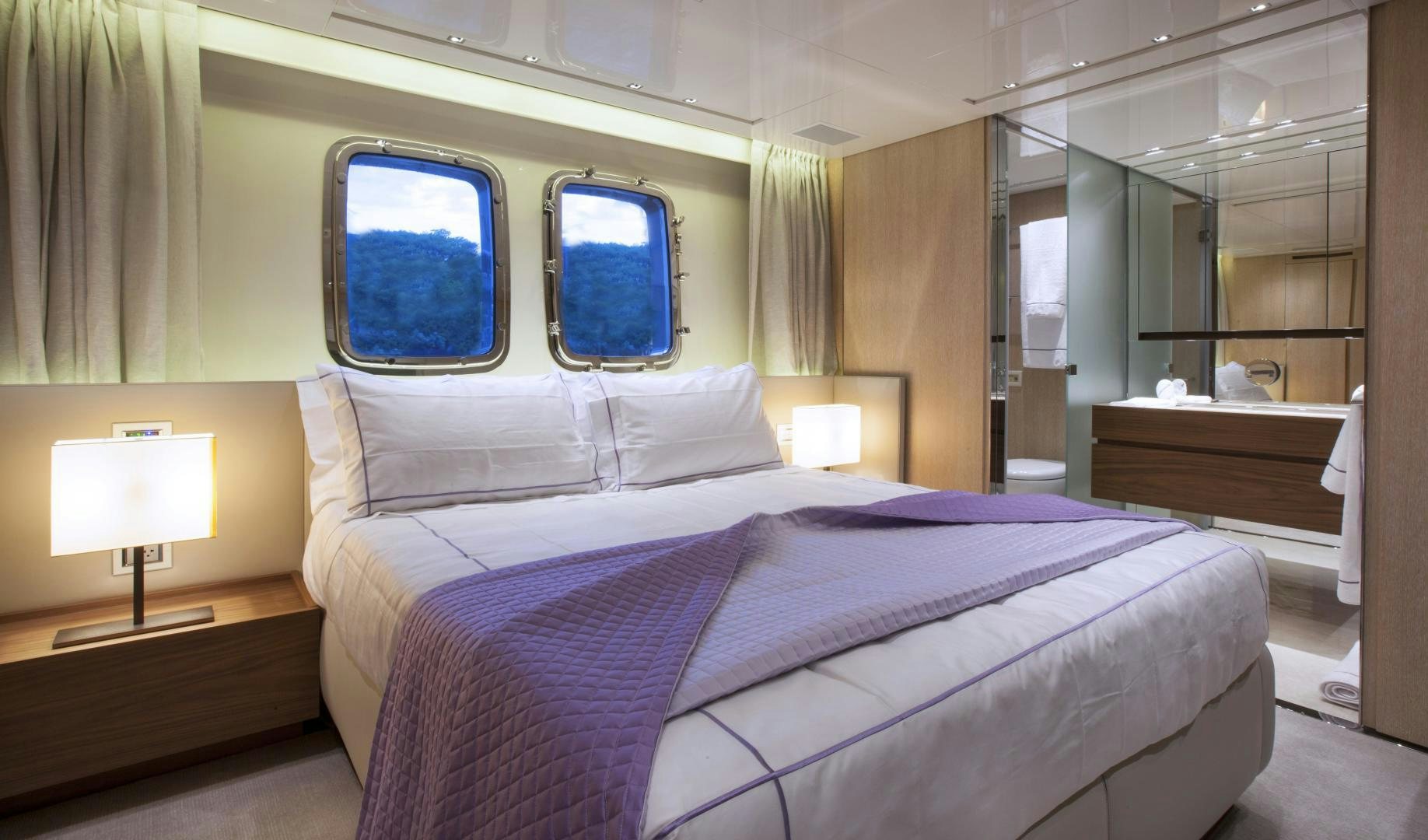 a bed with purple sheets aboard BODACIOUS Yacht for Sale