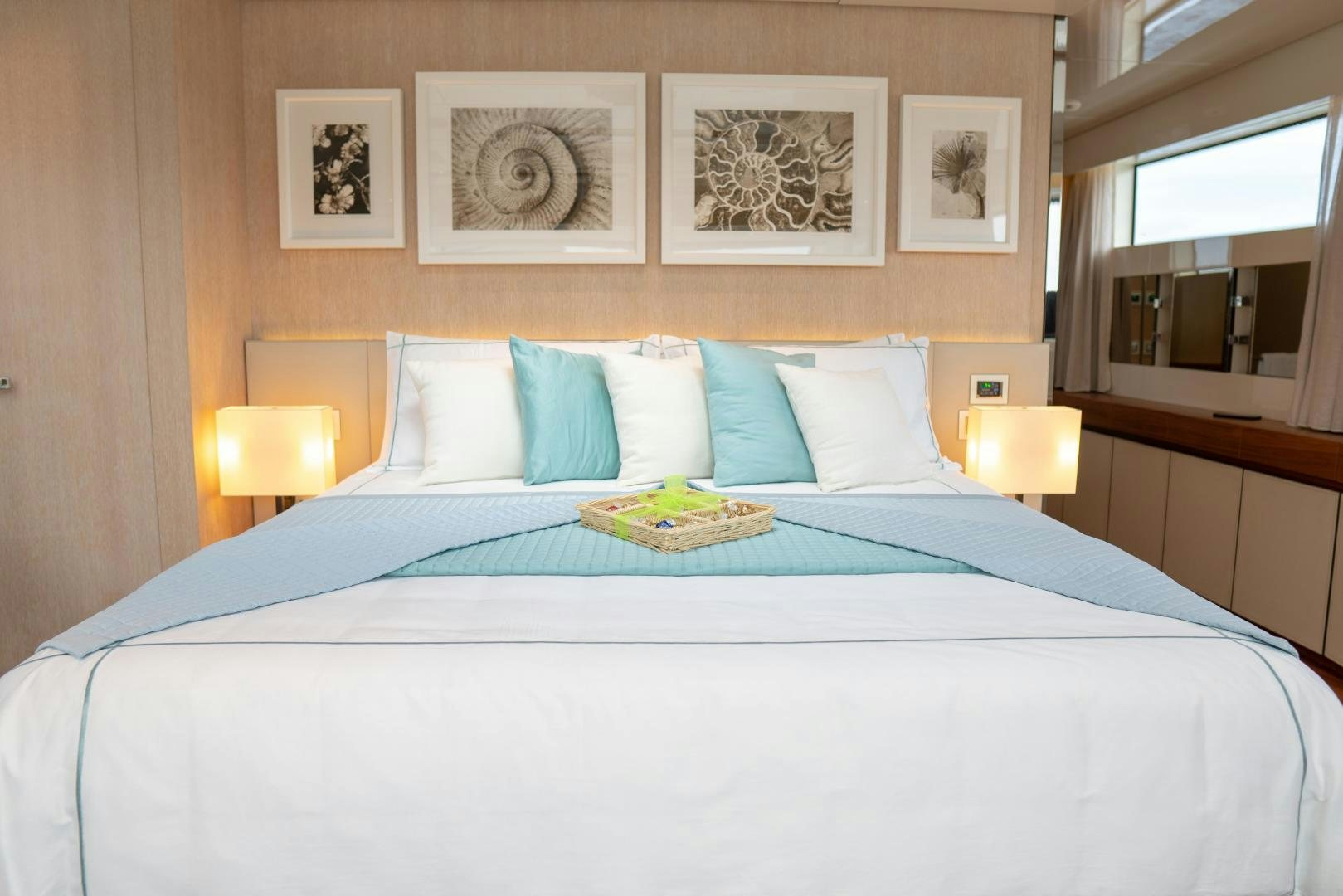 a bed with blue sheets and pillows aboard BODACIOUS Yacht for Sale