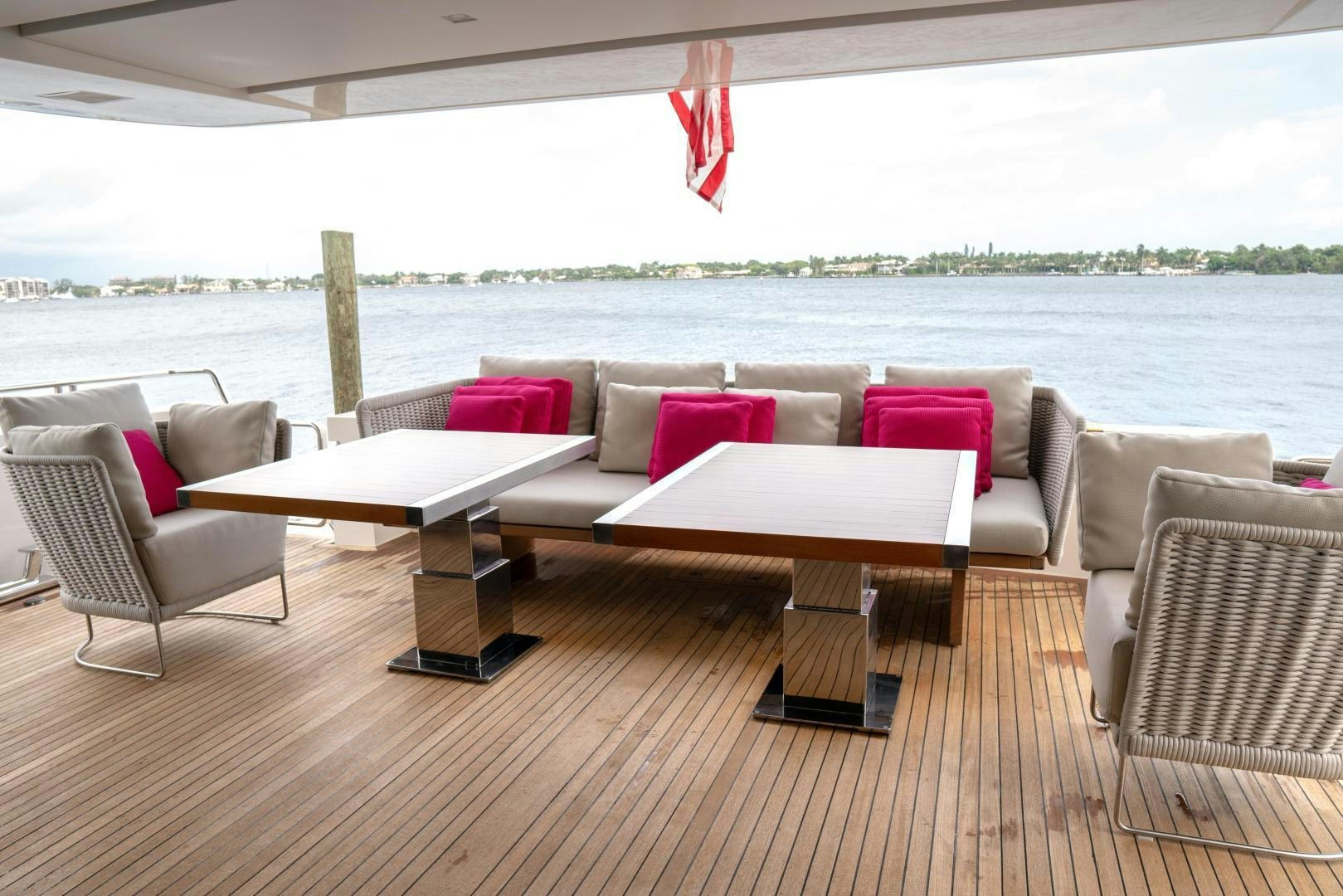 a large white couch and a table on a deck overlooking a body of water aboard BODACIOUS Yacht for Sale