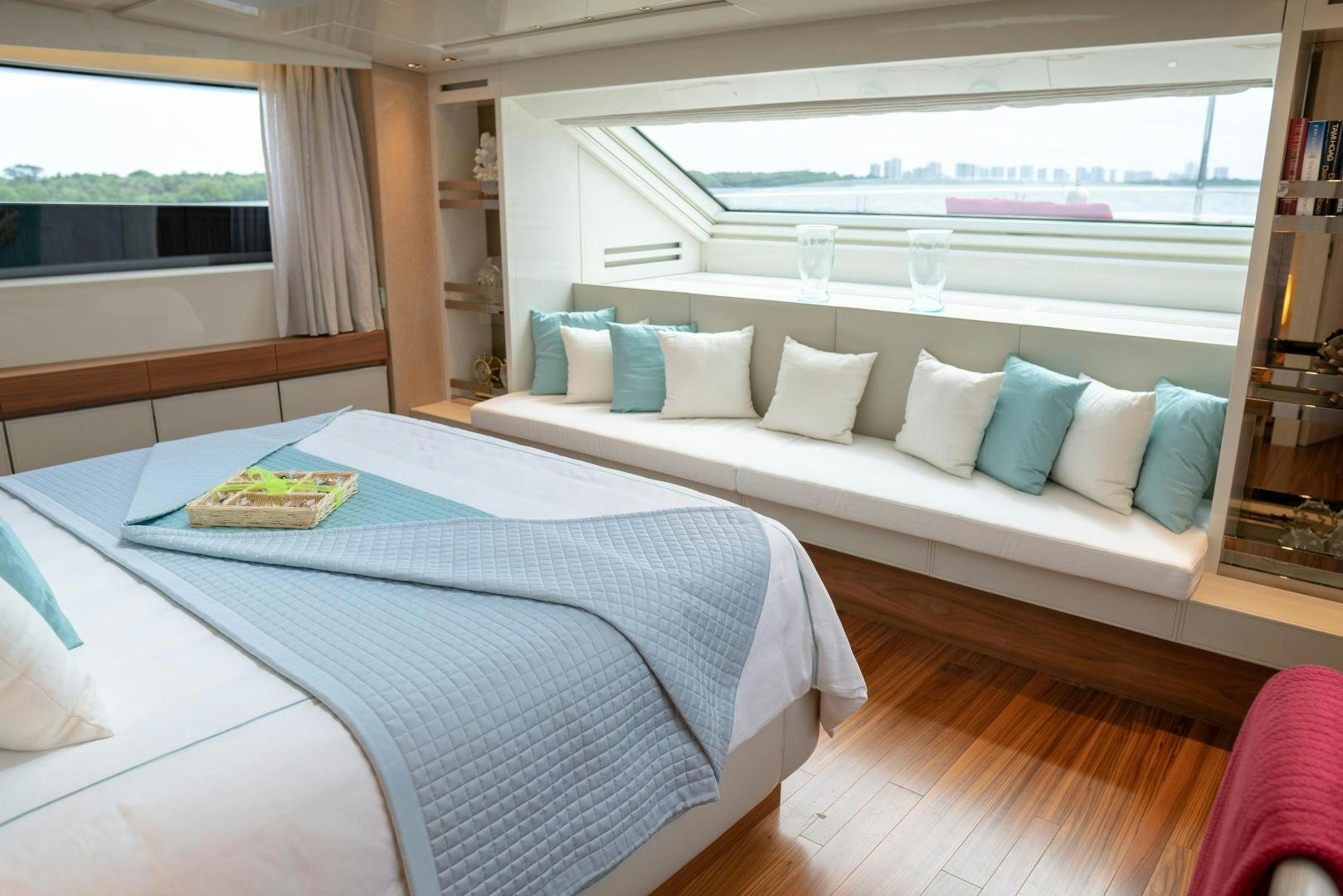 a bed with a blue sheet and pillows on it aboard BODACIOUS Yacht for Sale