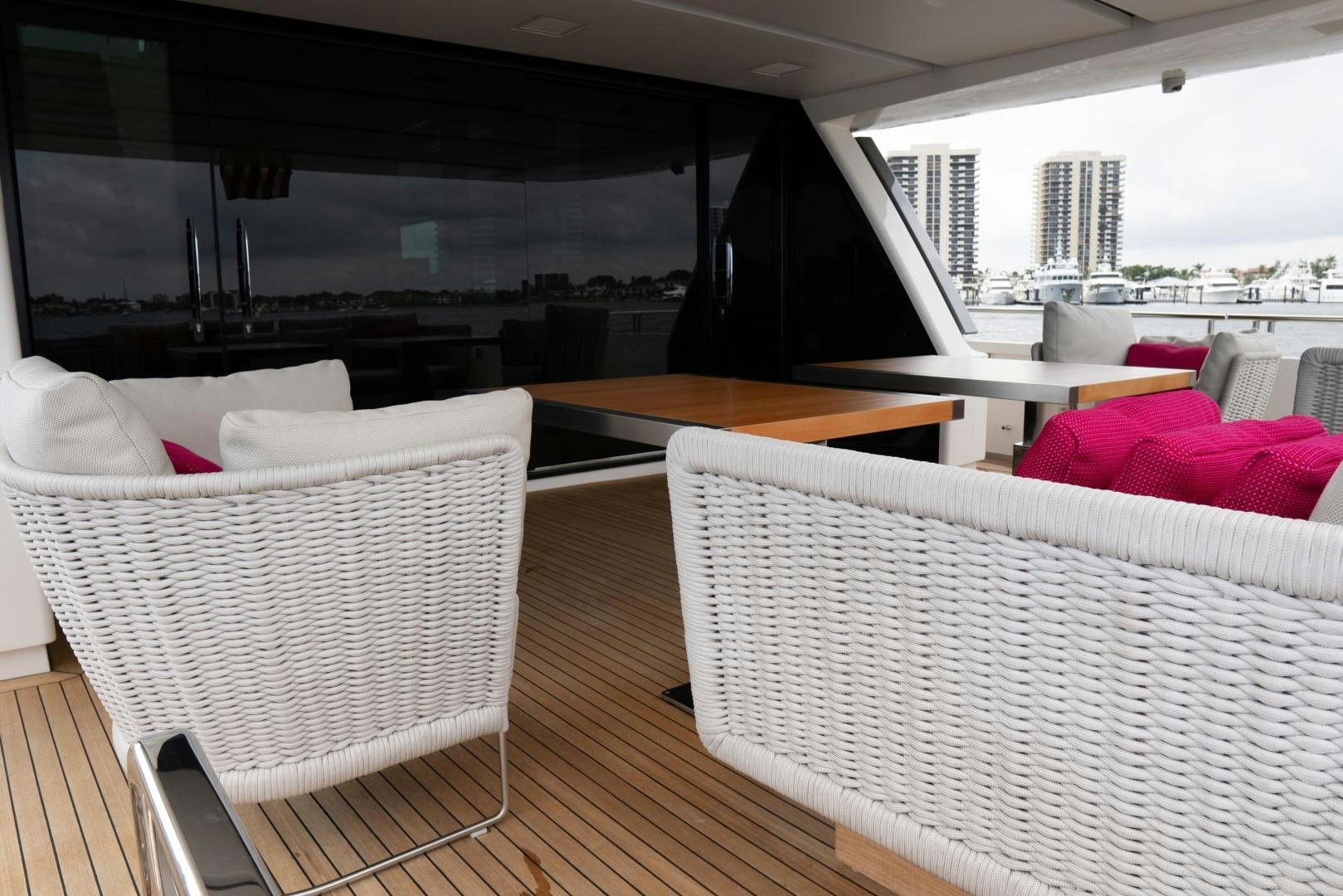 a room with a wood floor and white chairs and a large window aboard BODACIOUS Yacht for Sale