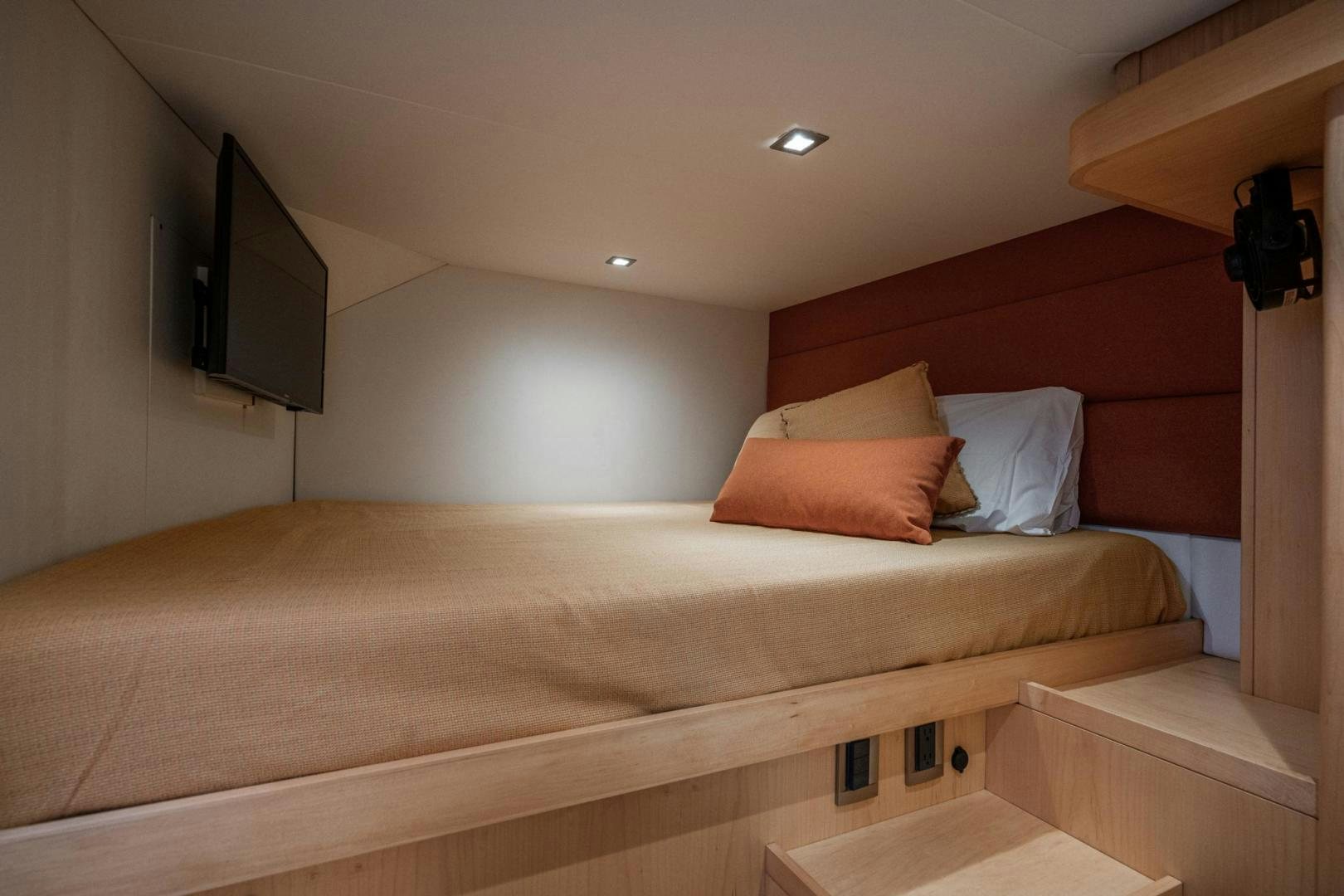 a bed with a television on the wall aboard MY CAT Yacht for Sale