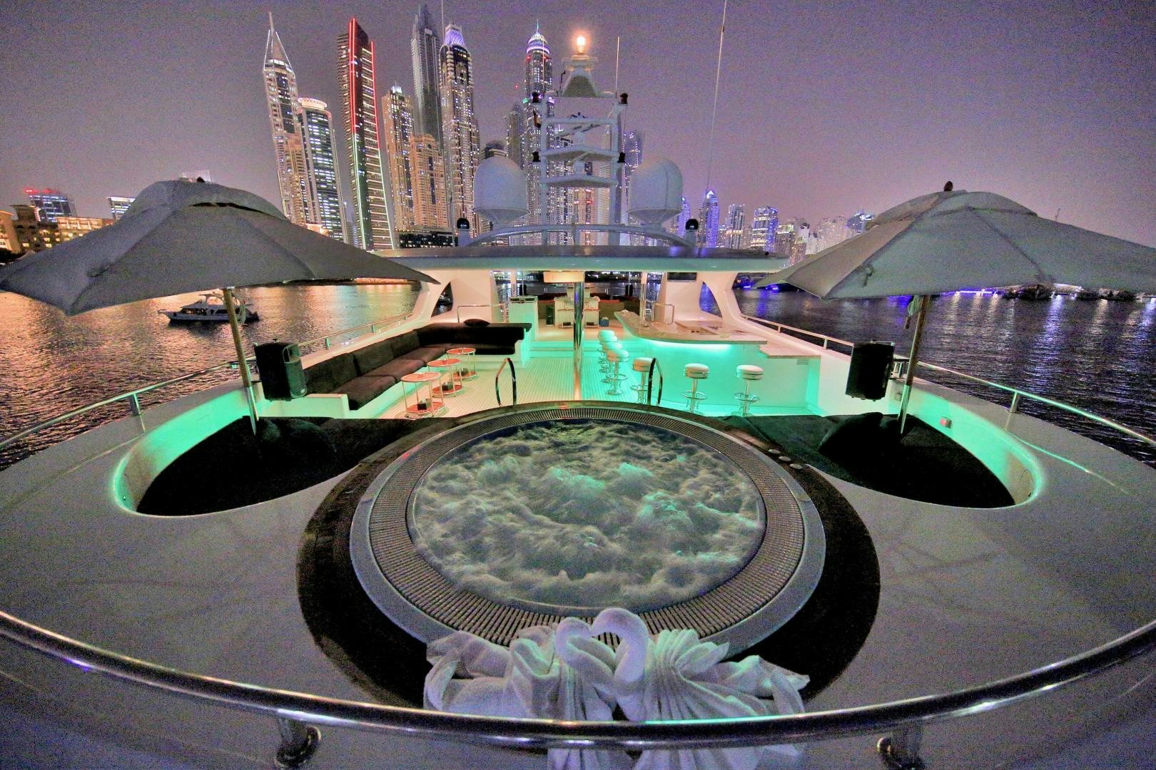 a pool with a city in the background aboard SOJO Yacht for Sale
