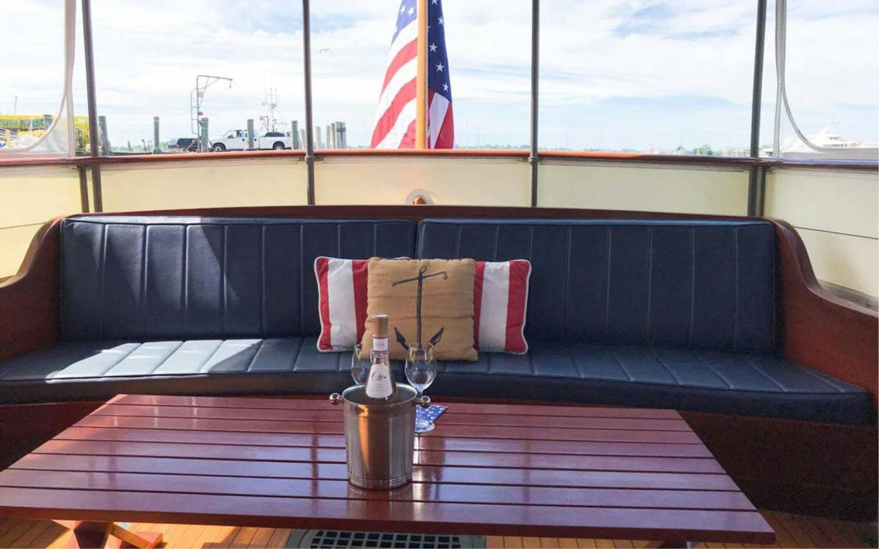 a table with a glass and a bottle of wine on it aboard SCOUT Yacht for Sale