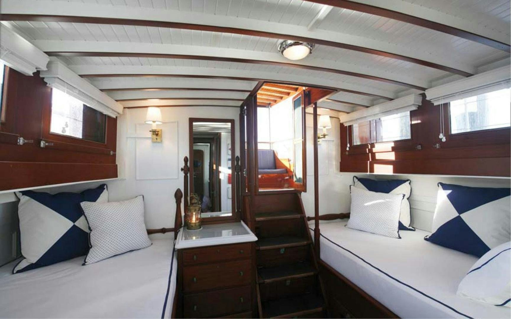 a room with a bed and a wood staircase aboard SCOUT Yacht for Sale