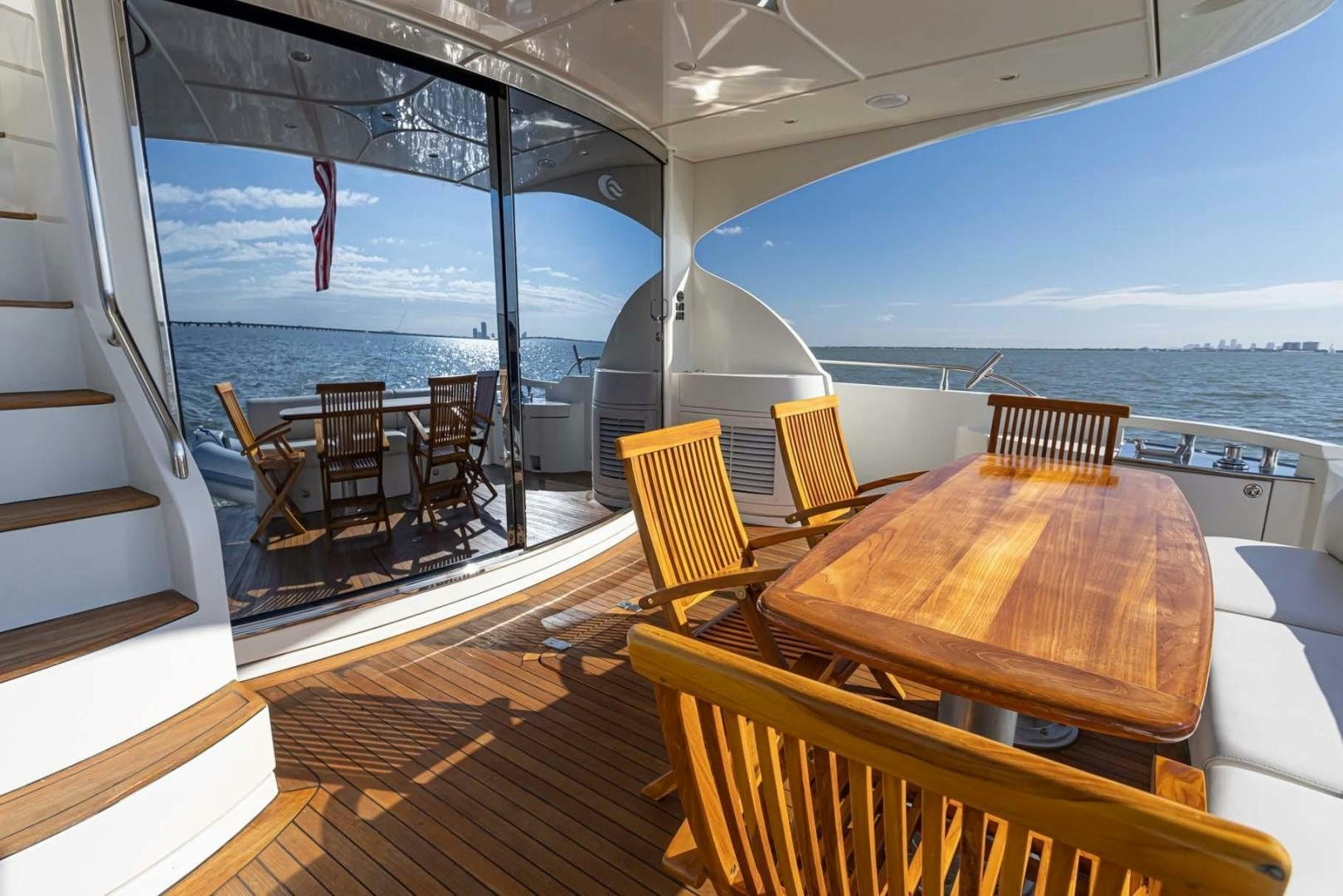 a deck with tables and chairs on it aboard DECKED OUT Yacht for Sale
