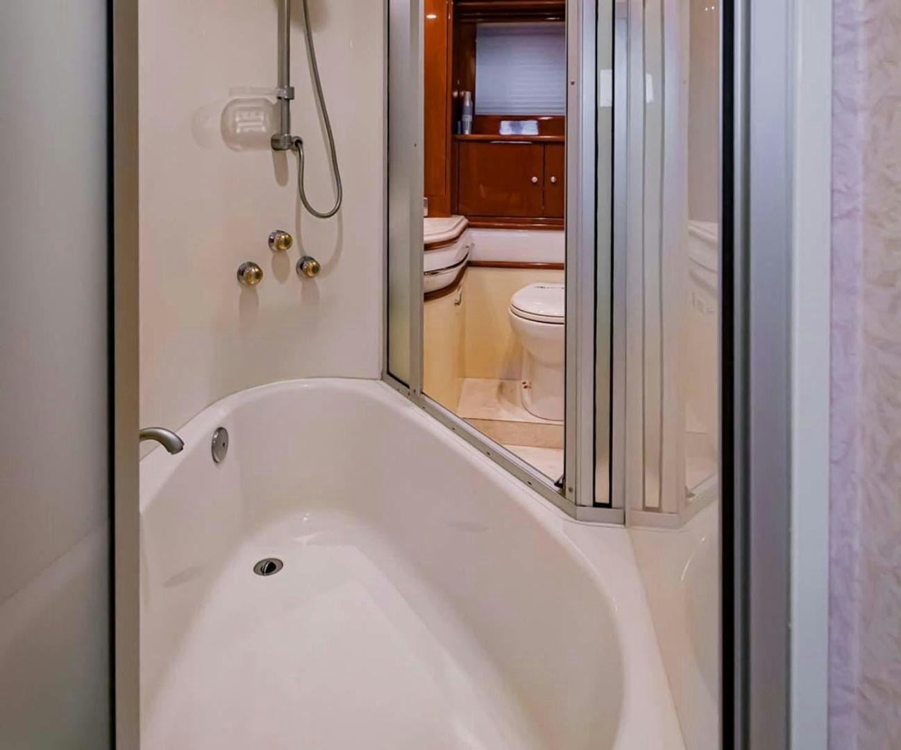 a bathroom with a tub and toilet aboard DECKED OUT Yacht for Sale