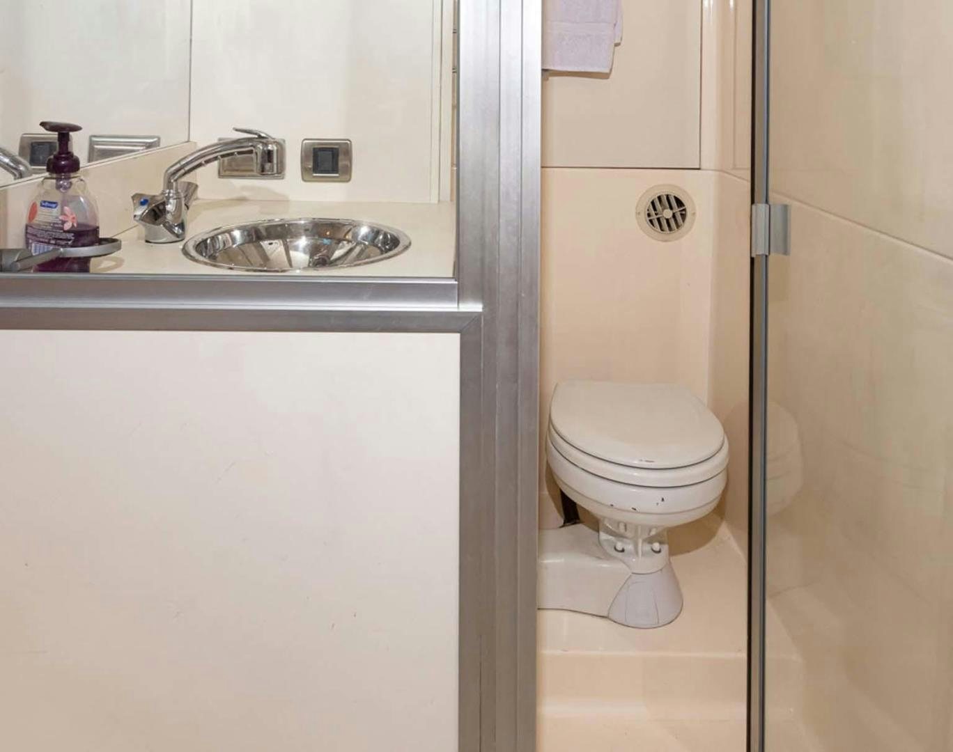 a bathroom with a sink toilet and a mirror aboard DECKED OUT Yacht for Sale