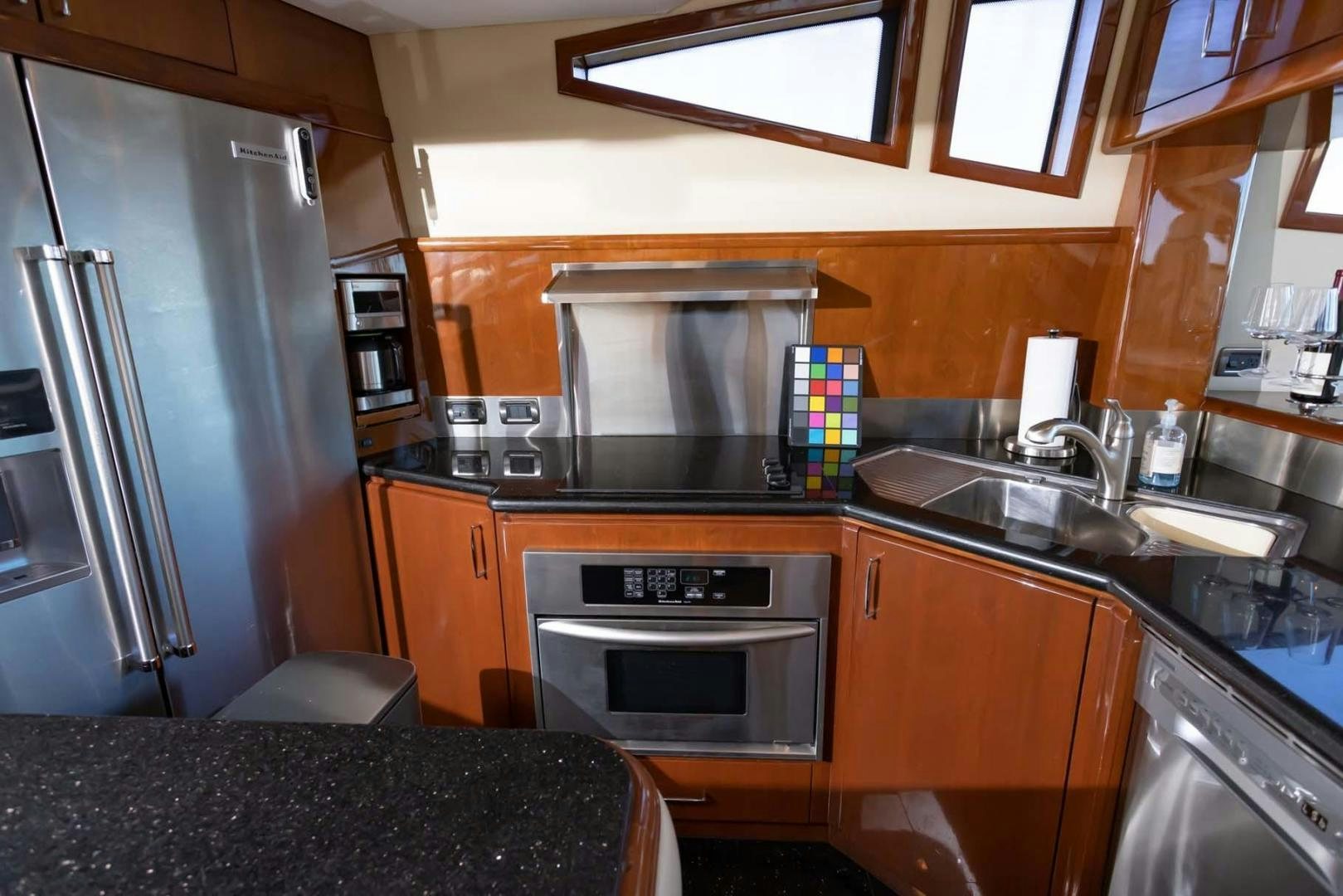 a kitchen with a stainless steel refrigerator aboard DECKED OUT Yacht for Sale