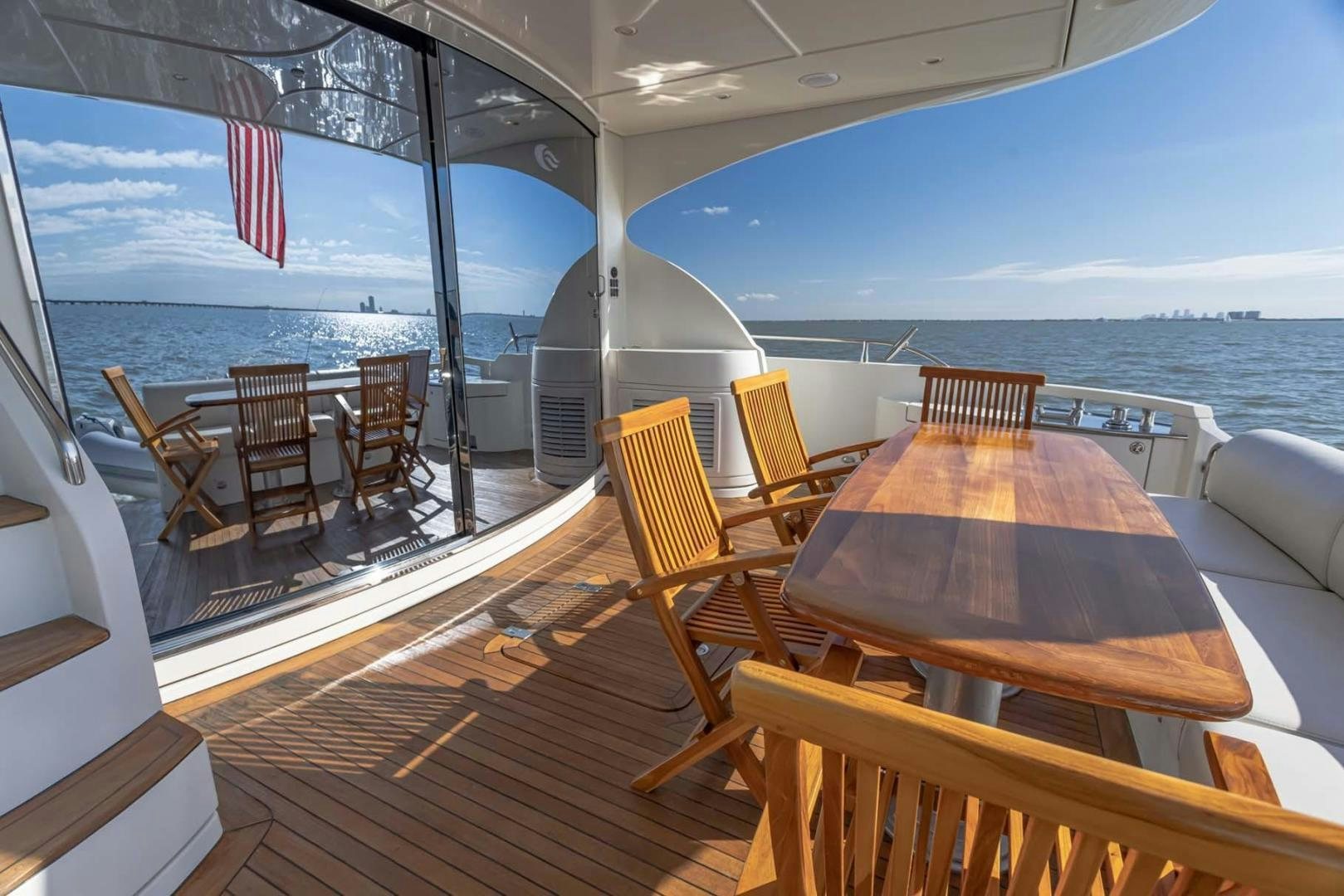 a deck with a table and chairs on it aboard DECKED OUT Yacht for Sale