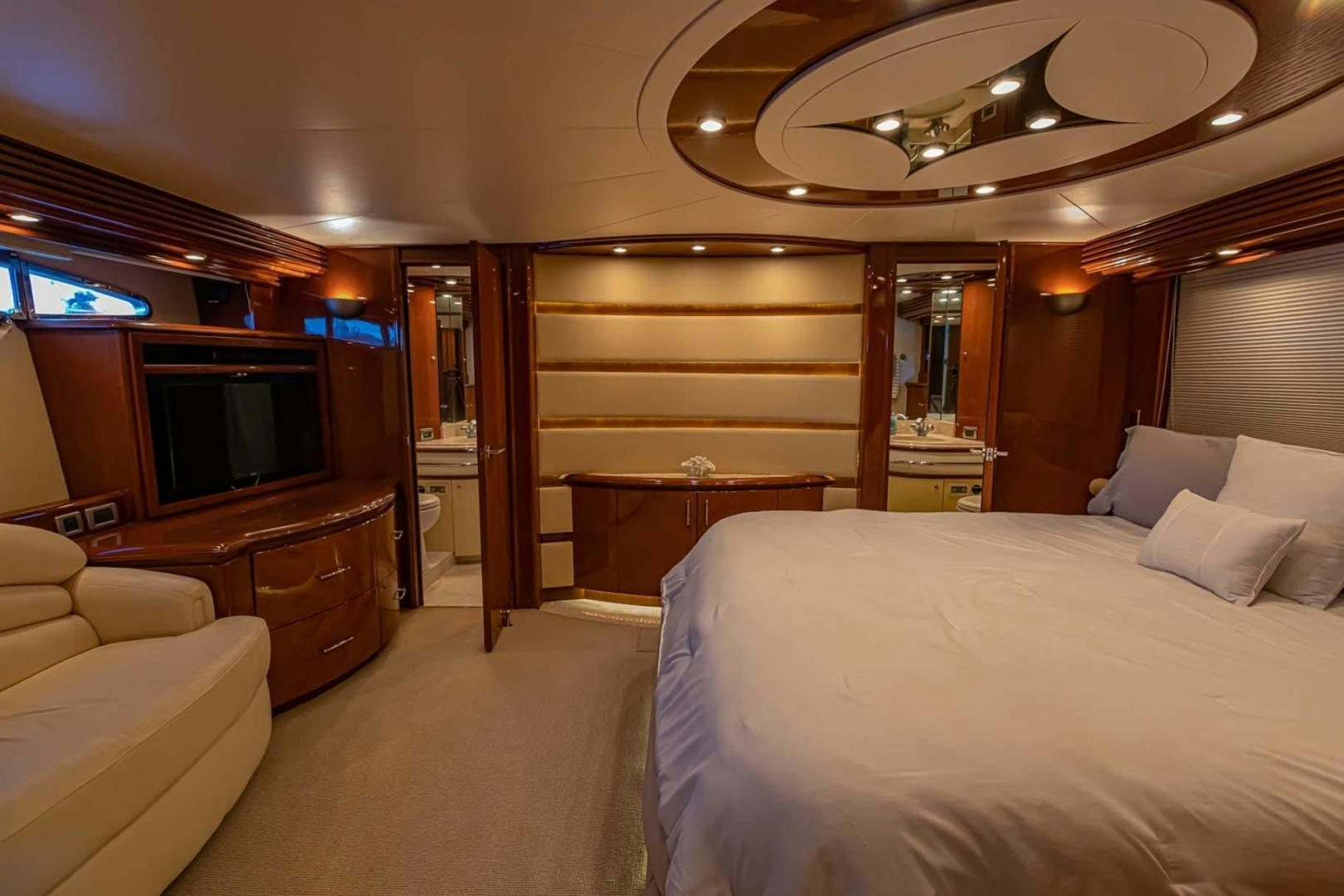 a room with a bed and a television aboard DECKED OUT Yacht for Sale