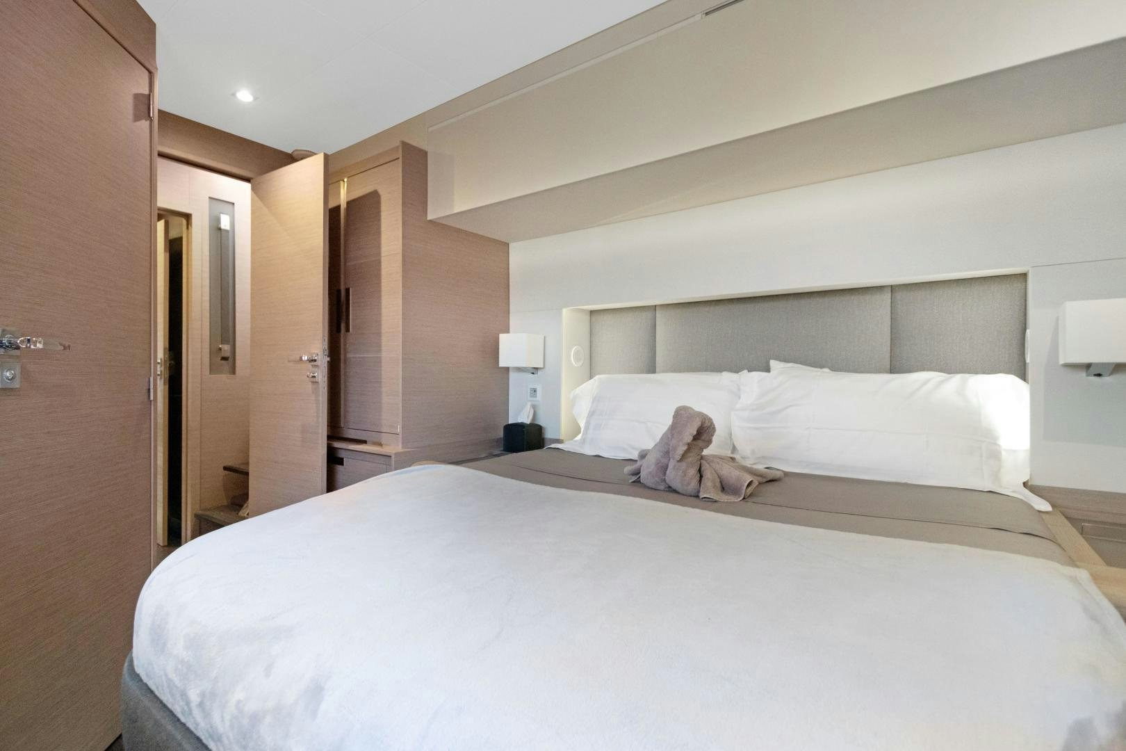 a bed with white sheets aboard Ocean Seven Yacht for Sale