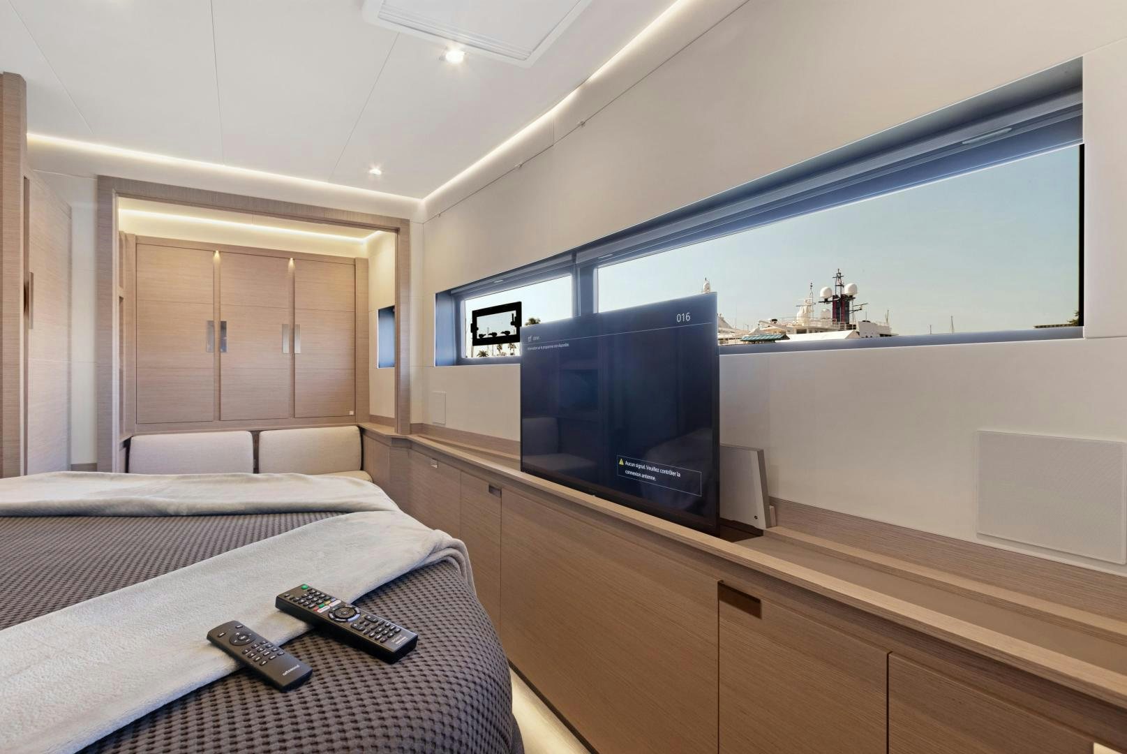 a room with a tv and a bed aboard Ocean Seven Yacht for Sale