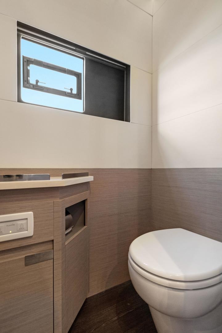 a bathroom with a toilet and a sink aboard Ocean Seven Yacht for Sale