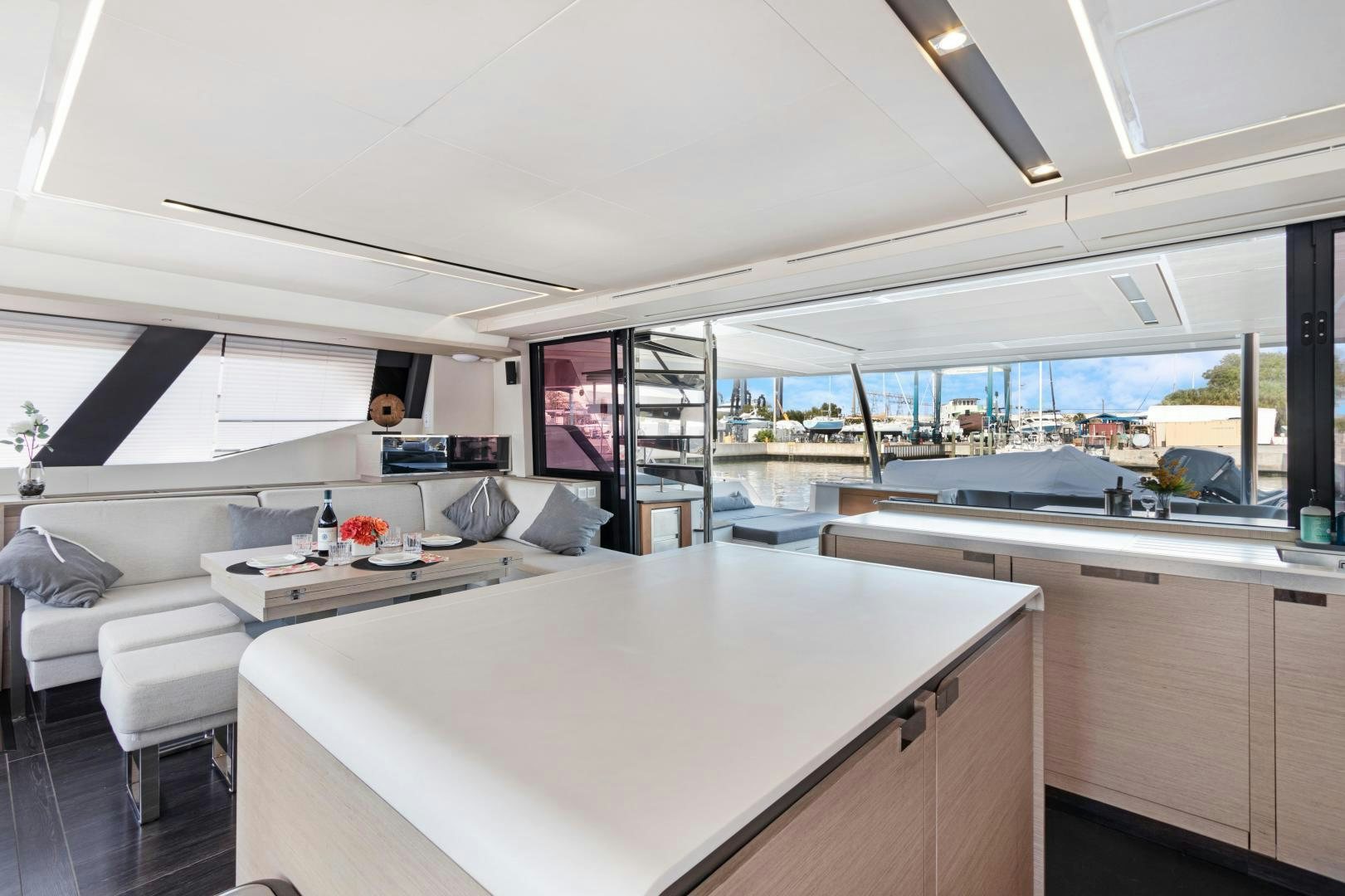 a room with a large white table and a large window aboard Ocean Seven Yacht for Sale