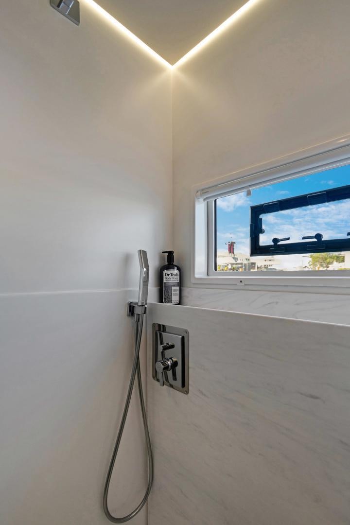 a wall with a window and a wall with a television on it aboard Ocean Seven Yacht for Sale