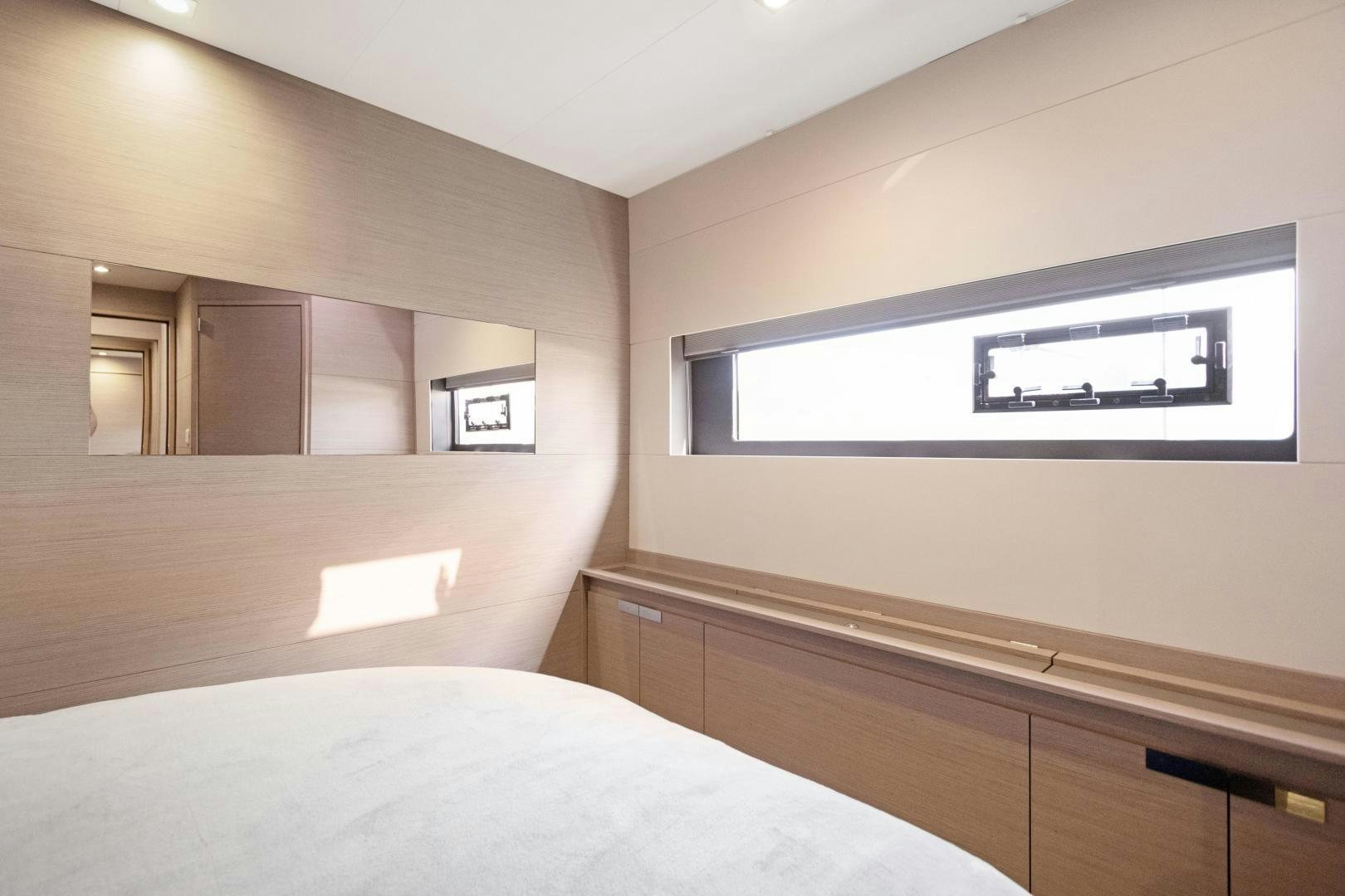 a room with a bed and a television on the wall aboard Ocean Seven Yacht for Sale