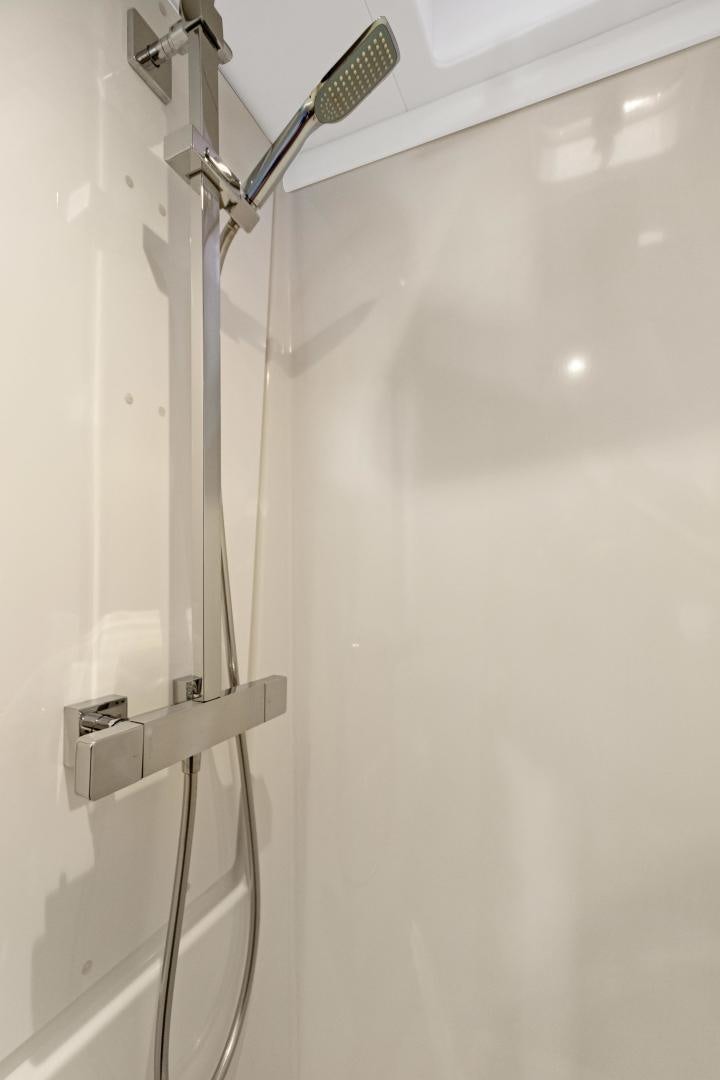 a white wall with a shower head aboard Ocean Seven Yacht for Sale