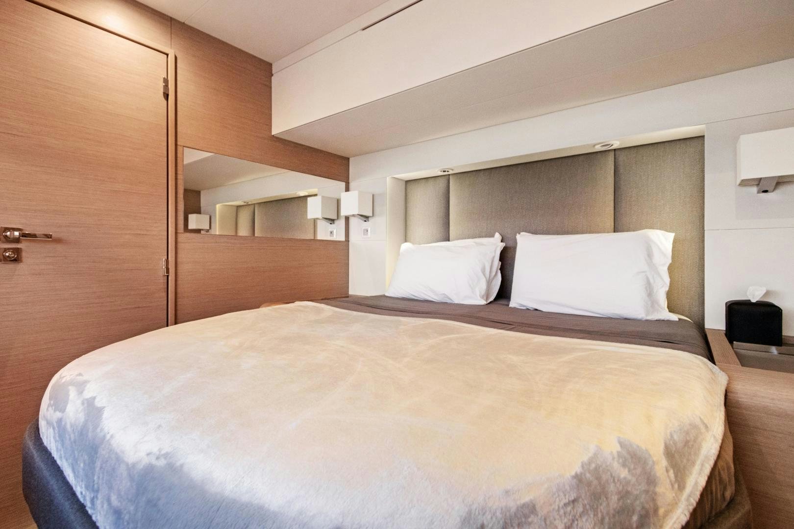 a bed with white pillows aboard Ocean Seven Yacht for Sale
