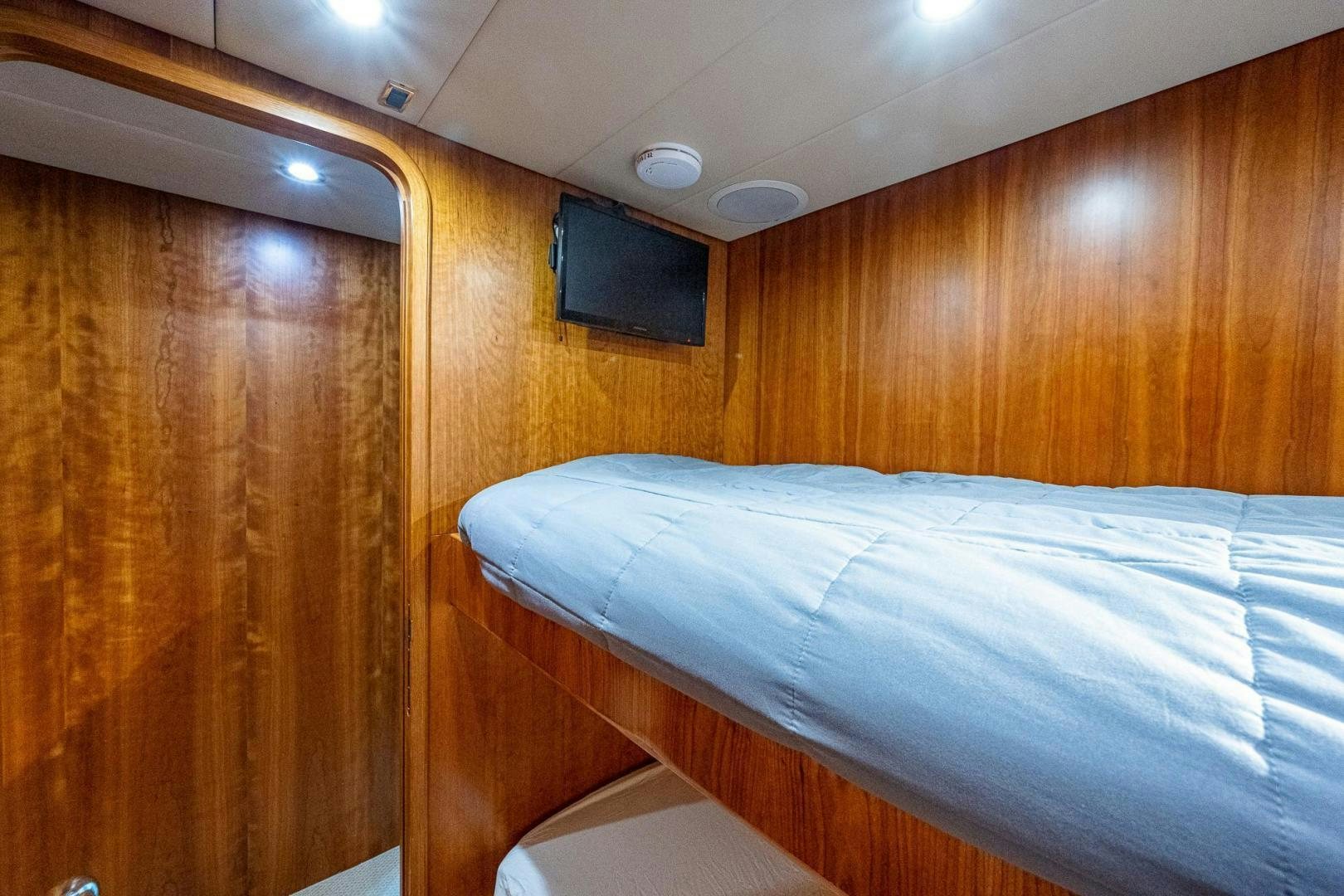 a bed with a wooden headboard aboard ODYSSEY Yacht for Sale