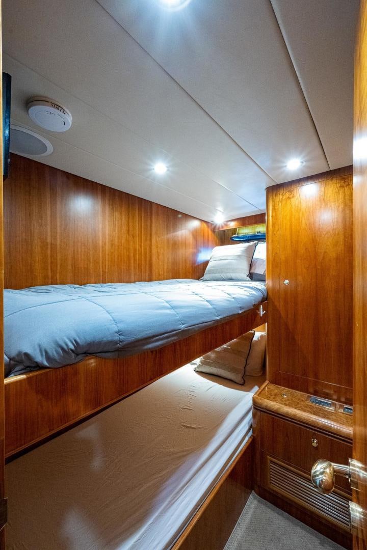 a bed with a wooden headboard aboard ODYSSEY Yacht for Sale